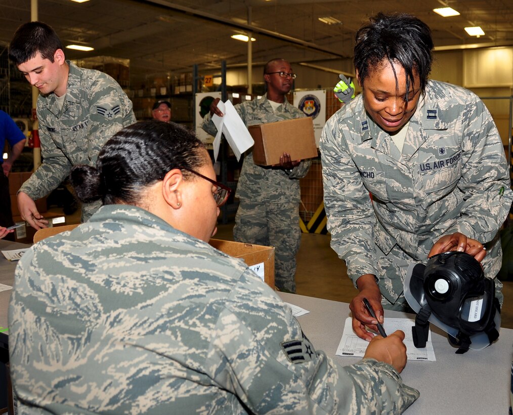Captain Marcela Sancho, 932nd Officer in Charge of Nursing Operations, Aeromedical Staging Squadron, is issued a gas mask for a training exercise, at Scott Air Force Base, Il, June 16, 2014.  Capt. Sancho is in charge of making sure that the medical technicians in the ASTS are certified in all the skill sets they are required to master for their jobs. (U.S. Air Force Photo/ Staff Sgt. Amber Hodges)