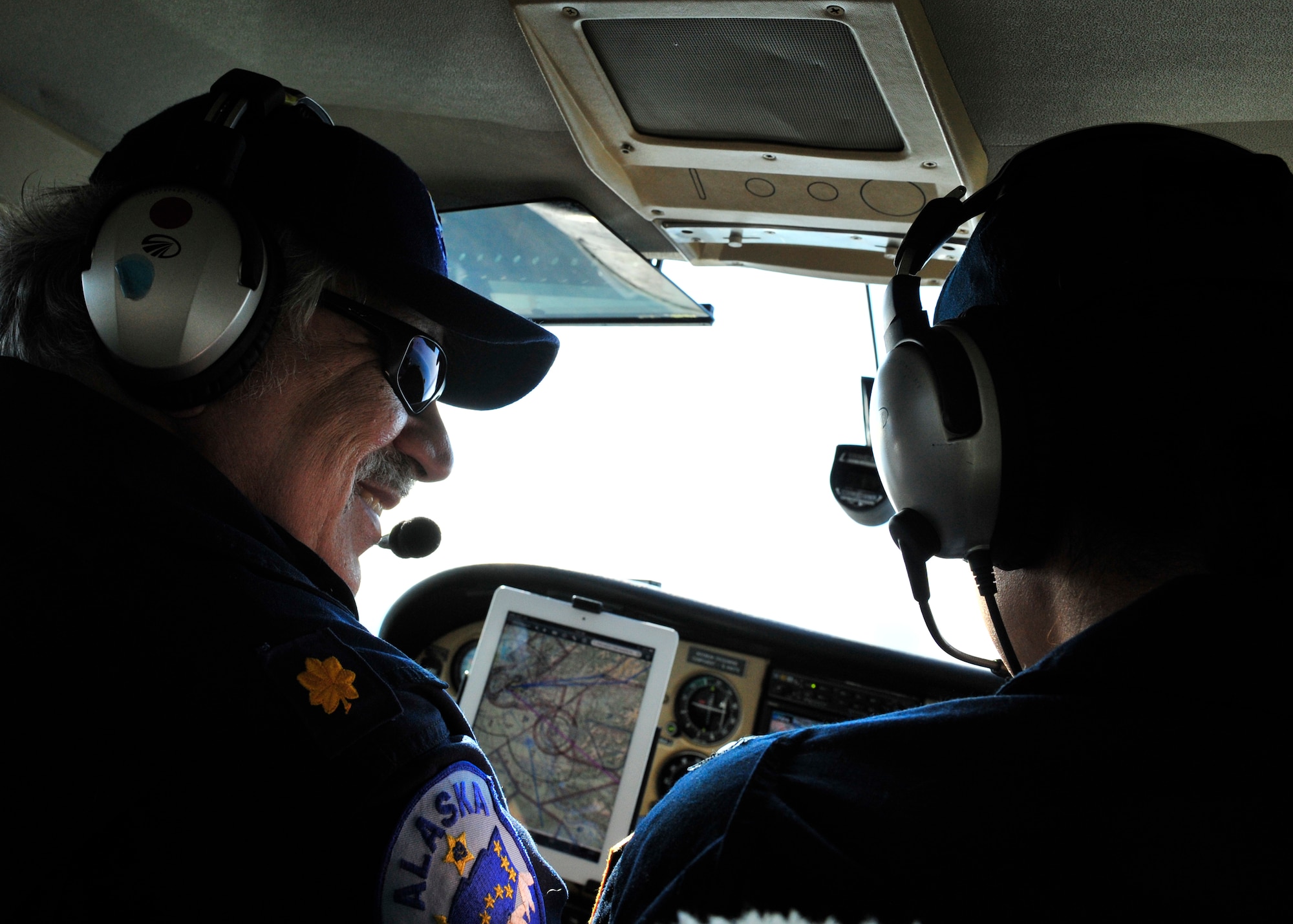 Jim Gibertoni, 9th Composite Operations Squadron member, communicates with co-pilot Caleb Conley, 9th COS, during a Civil Air Patrol flight May 21, 2014, Fairbanks, Alaska. As members of CAP, Gibertoni and Conley act as aerial targets for other pilots participating in RED FLAG-Alaska. (U.S. Air Force photo by Senior Airman Ashley Nicole Taylor/Released)