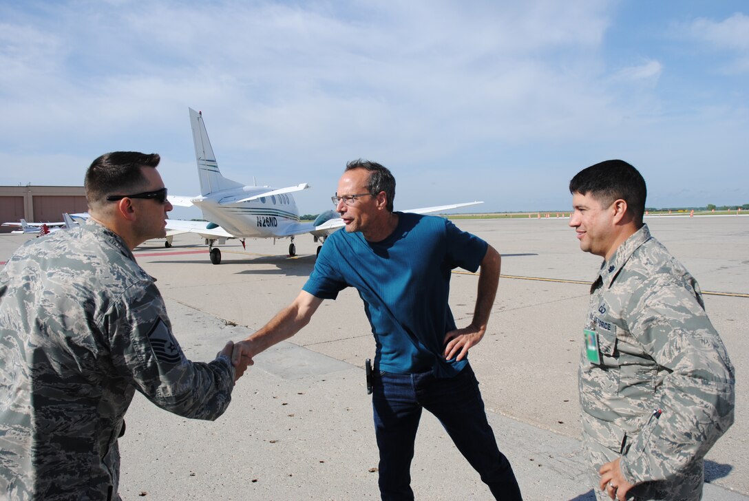 David Gust, president of the North Dakota Agricultural Aviation Association, reaches to shake the hand of Master Sgt. Daniel Shannon, superintendent of the 319th Air Base Wing safety, after initially being greeted by Lt. Col. Rudolf Kuehne, the 319th ABW chief of safety, minutes after he landed his BE-35B Beechcraft on Grand Forks Air Force Base, N.D.,in order to attend the 2014 M.A.C.A. Civil Fly-In held June 14, 2014. Gust was one of 55 people from various flying clubs and organization that attended the event in support of the base’s Mid-Air Collision Avoidance program, which is what M.A.C.A. stands for. (U.S. Air Force photo/Staff Sgt. Luis Loza Gutierrez)