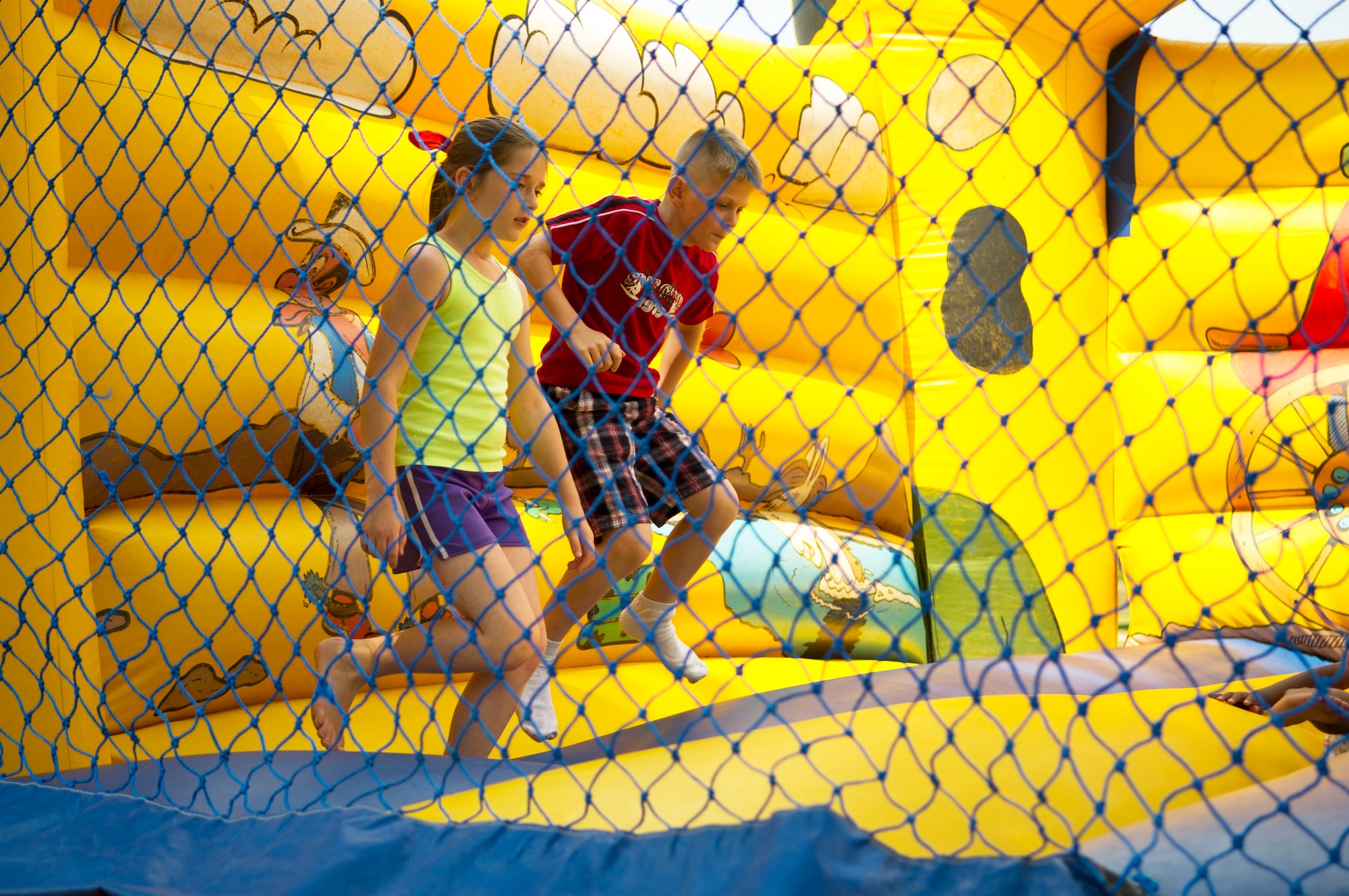 A pair of young Team Andrews members jump around at the Andrews Library's 'Paws to Read' summer reading program kickoff party at Joint Base Andrews, Md., June 16, 2014. The program encourages children to read during the summer months and the library is slated to host weekly events for children to attend. (U.S. Air Force photo/Staff Sgt. Torey Griffith)