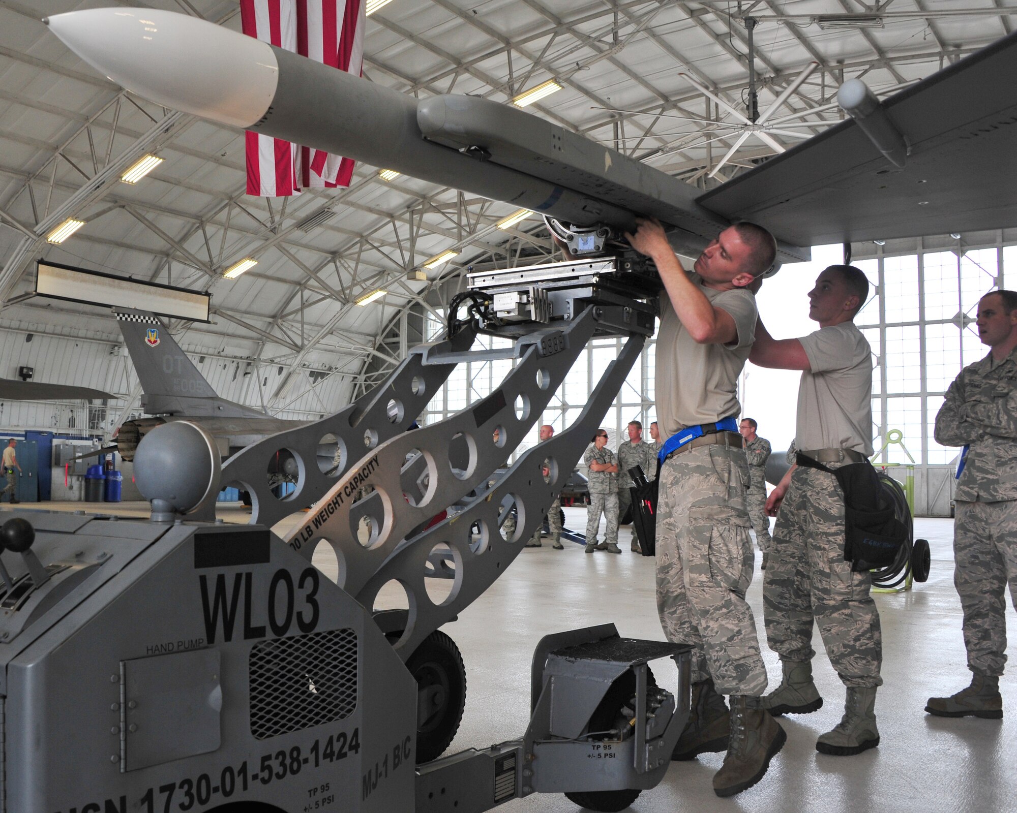 Staff Sgt. Talesian Colby and Airmen 1st Class Trey Riley, of the 96h Aircraft Maintenance Squadron Blue, load a CATM-120 missile on an F-16 Fighting Falcon during the 96th Maintenance Group’s quarterly weapons load crew competition June 13 at Eglin Air Force Base, Fla.  Colby, Riley and Airman 1st Class Caitlyn Nolin lost to the Red AMU F-15 team.  (U.S. Air Force photo/Ilka Cole)