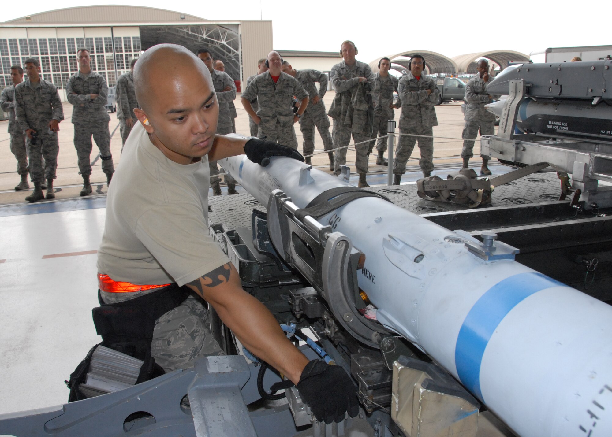 Staff Sgt. Adrian Pamintuan, of the 96th Aircraft Maintenance Squadron Red, secures a CATM-120 missile for loading onto the F-15 Strike Eagle, during the 96th Maintenance Group’s quarterly weapons load crew competition June 13 at Eglin Air Force Base, Fla. Pamintuan, Senior Airman Luis Cleveland and Airman 1st Class Luke Odom, won the competition.  (U.S. Air Force photo/Kevin Gaddie)