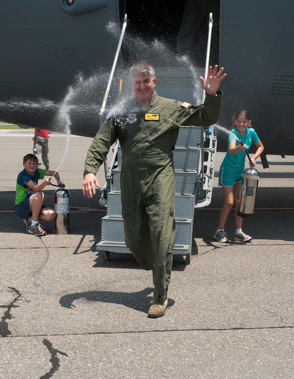 Col. Al Miller, 437th Airlift Wing vice commander, gets sprayed by his son, Austin and daughter Lindsay, after finishing his final flight as the 437th Airlift Wing vice commander May 16, 2014, on the flightline at Joint Base Charleston, S.C. The final or "fini flight," is an aviation tradition in which aircrew members are met by their unit comrades, family and friends and then soaked with water. (U.S. Air Force photo/ Staff Sgt. William A. O’Brien)