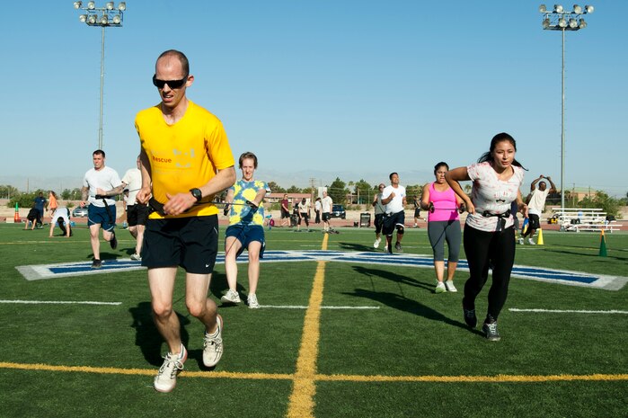 Athletes run while being restrained during a Warrior Trained Fitness workout session at the Warrior Fitness Center June 12, 2014, at Nellis Air Force Base, Nev. The session consisted of several exercise stations to work different muscles throughout the body. (U.S. Air Force photo by Senior Airman Timothy Young)