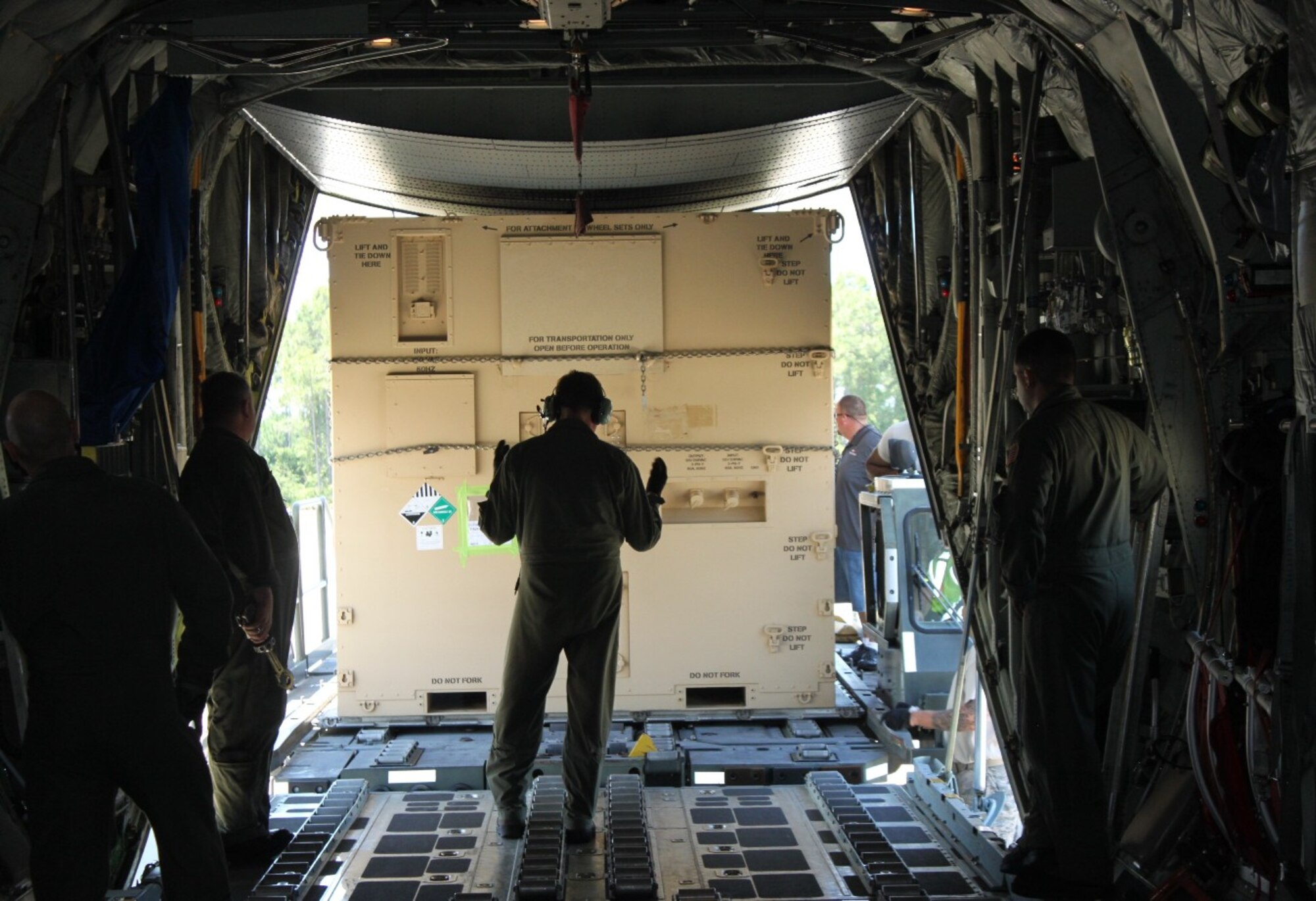 Airmen load a Hardside Expandable Light Air Mobile Shelter, or HELAM, on to a Navy C-130 June 13 in support of Naval exercise “Rim of the Pacific." Personnel from the 325th Logistics Readiness Squadron participated in the joint operation by loading cargo and equipment in to the aircraft. (U.S. Navy courtesy photo)