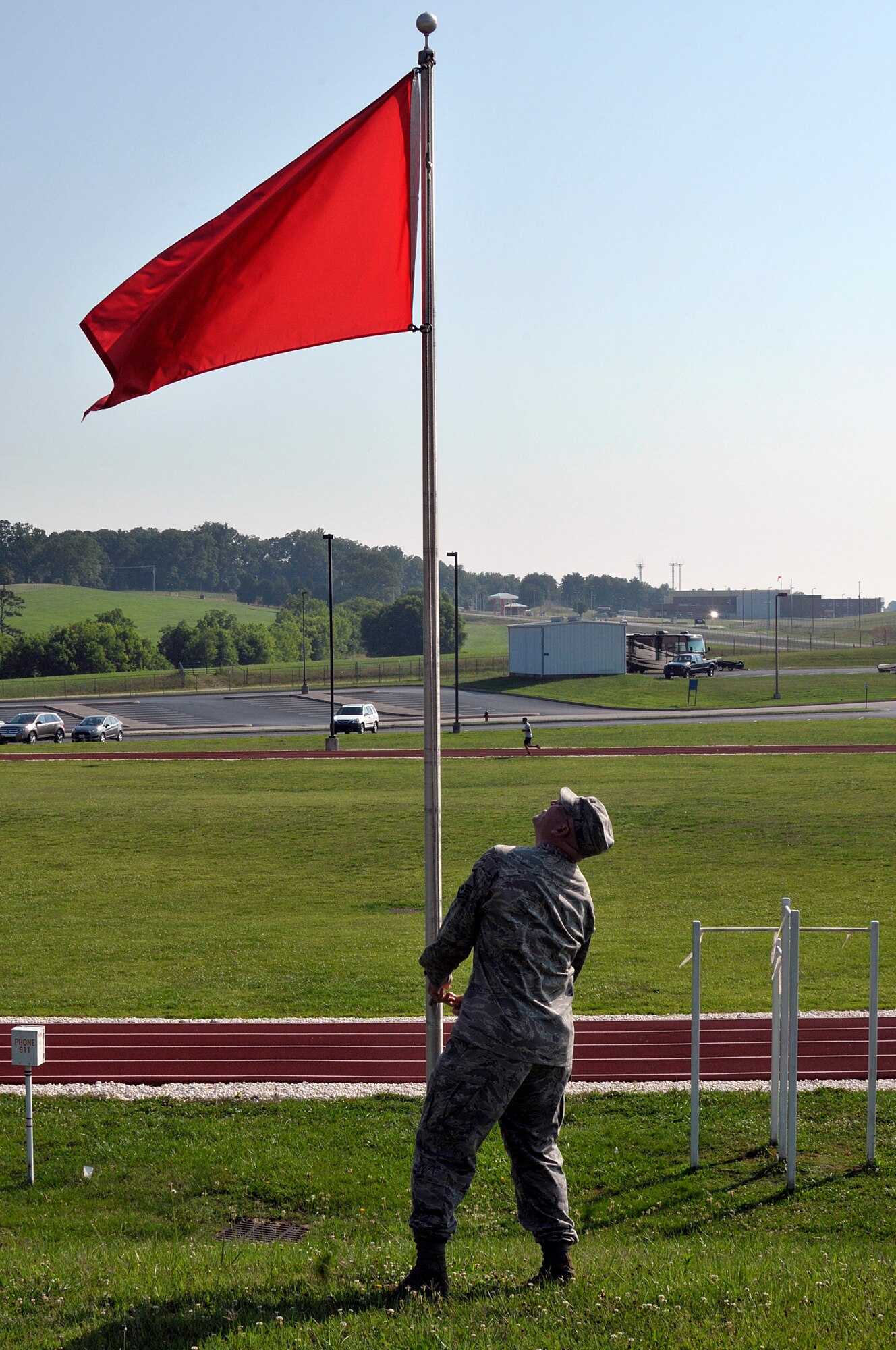 MCGHEE TYSON AIR NATIONAL GUARD BASE, Tenn. - Master Sgt. Don Pierson, logistics manager for the I.G. Brown Training and Education Center, raises a Red Flag Condition June 17, 2014, at the campus's running track. (U.S. Air National Guard photo by Master Sgt. Mike R. Smith/Released)