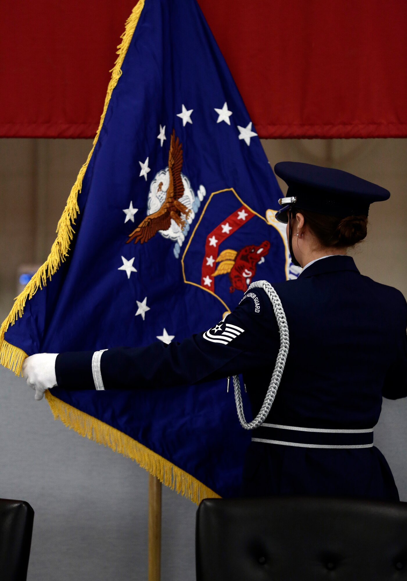Tech Sgt. Jean Schnauffer, right, carries the new 188th Wing flag while Staff Sgt. Caressa Soriano, left, carries the furled 188th Fighter Wing flag as Senior Airman Richard Green stands at attention during a Conversion Day ceremony held at Ebbing Air National Guard Base, Fort Smith, Arkansas, June 7, 2014. The ceremony was to recognize the many changes occurring at the wing as a result of its conversion to a remotely piloted aircraft (MQ-9 Reapers) and intelligence, surveillance and reconnaissance mission. The 188th Fighter Wing was redesignated as the 188th Wing during the event. (U.S. Air National Guard photo by Staff Sgt. Matthew Pelkey) 