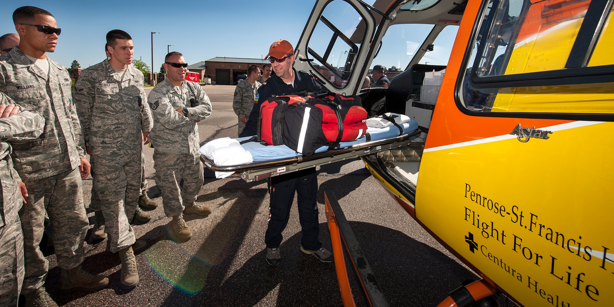 PETERSON AIR FORCE BASE, Colo. -- Rod Gano, Flight for Life Colorado paramedic, shows fire prevention technicians from the 21st Civil Engineer Squadron how to slide out a stretcher from the Flight for Life helicopter here June 13. Flight for Life Colorado held a training session with the local fire prevention team to gain familiarization with their operations in the event a patient needs rapid transport. (U.S. Air Force photo/Craig Denton)