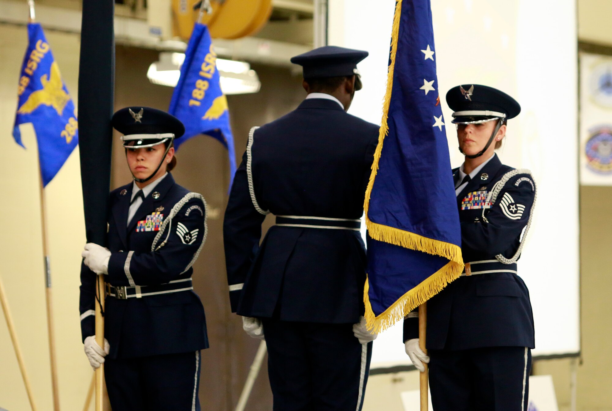 Tech Sgt. Jean Schnauffer, right, carries the new 188th Wing flag while Staff Sgt. Caressa Soriano, left, carries the furled 188th Fighter Wing flag as Senior Airman Richard Green stands at attention during a Conversion Day ceremony held at Ebbing Air National Guard Base, Fort Smith, Arkansas, June 7, 2014. The ceremony was to recognize the many changes occurring at the wing as a result of its conversion to a remotely piloted aircraft (MQ-9 Reapers) and intelligence, surveillance and reconnaissance mission. The 188th Fighter Wing was redesignated as the 188th Wing during the event. (U.S. Air National Guard photo by Staff Sgt. Matthew Pelkey) 