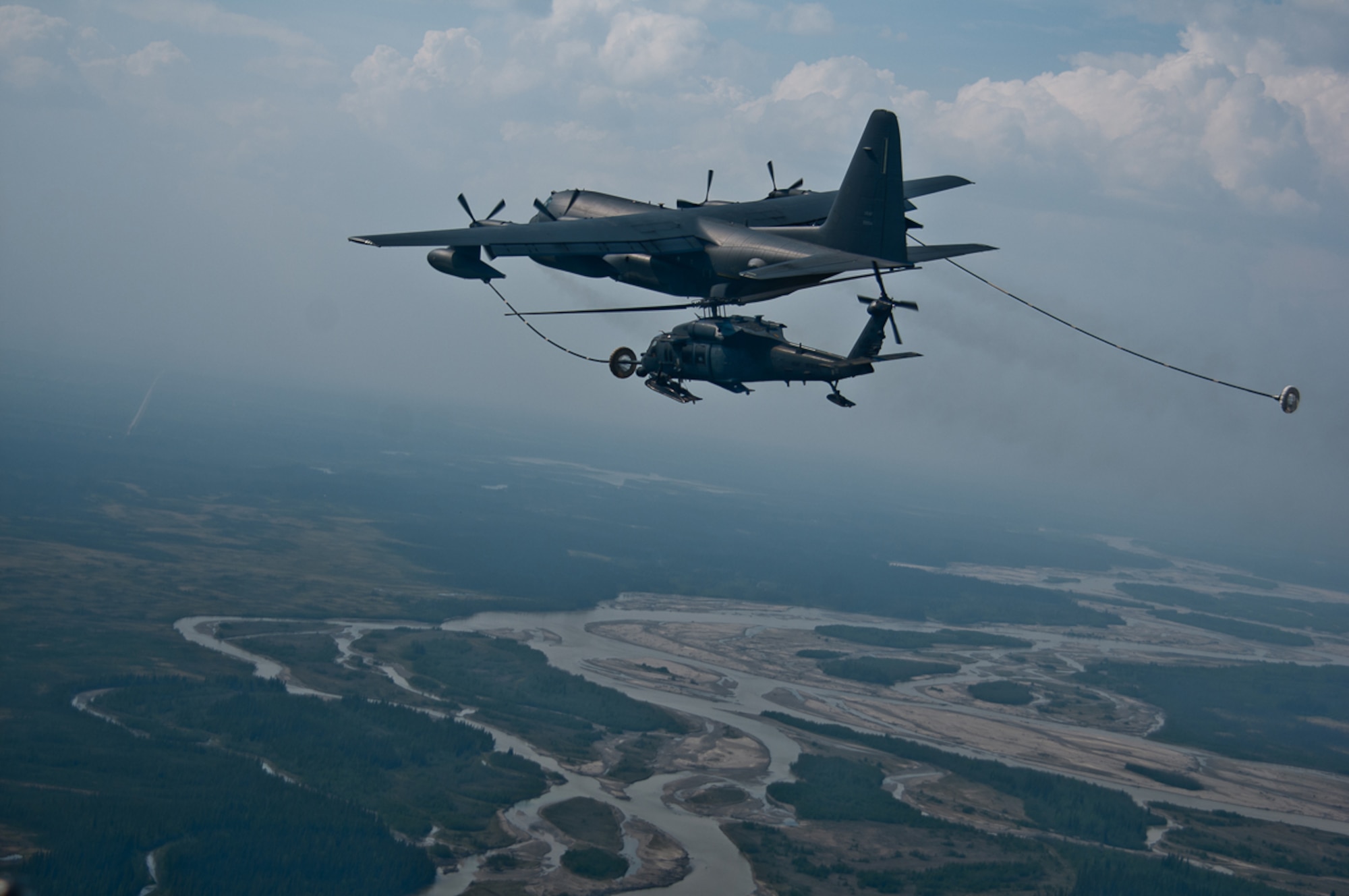 A HC-130P refuels a HH-60 Pave Hawk helicopter during the Joint Forcible Entry Exercise at Donnelly Training Area near Fort Greely Sunday. The exercise was part of a three-day, joint forcible-entry exercise to train on airfield seizure operations. (U.S. Army photo/Sgt. Eric-James Estrada)