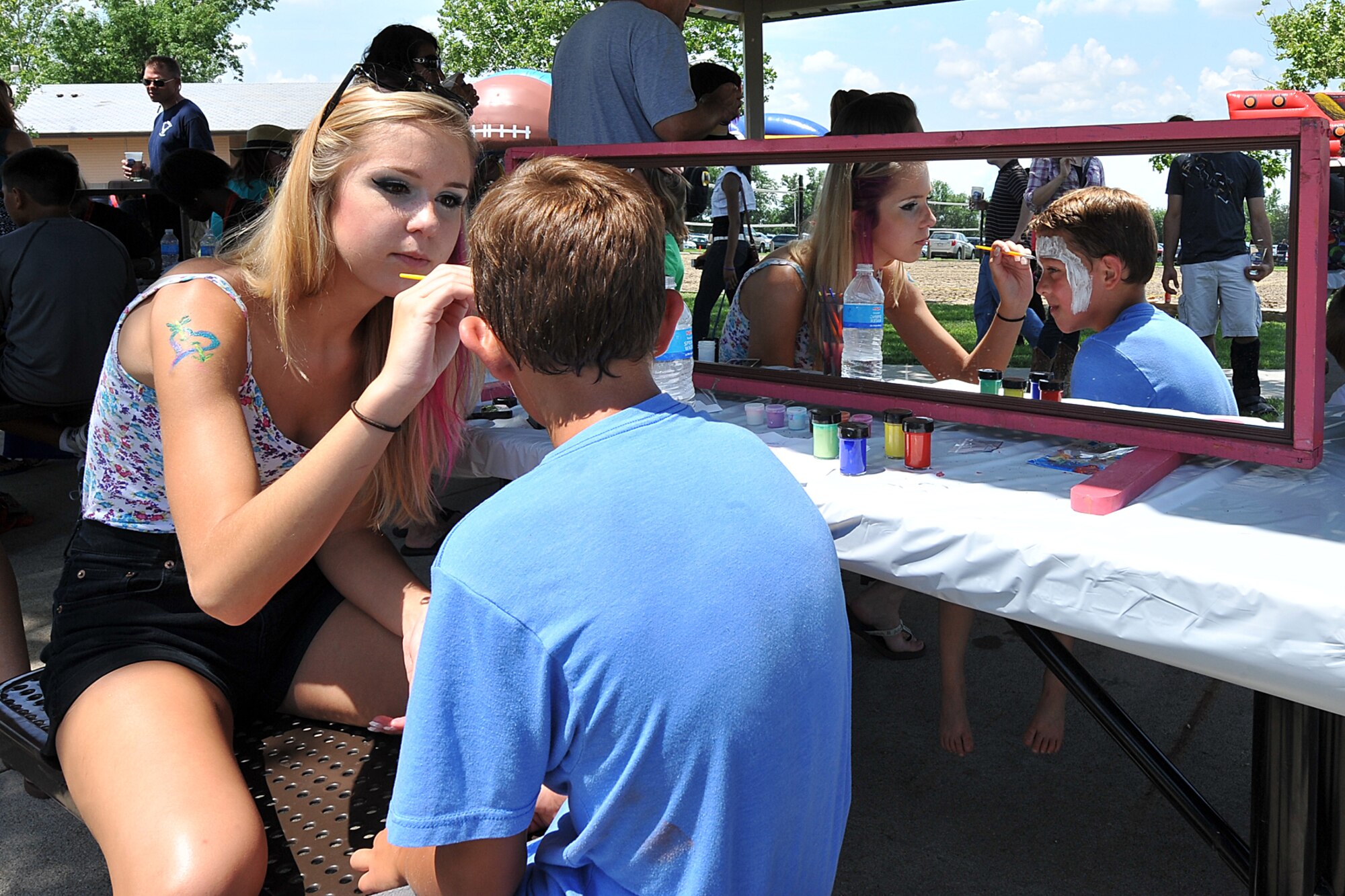 Brooklyn Barrett paints the face of her brother Hunter Witte during the Offutt Advisory Council’s annual Offutt Appreciation Day Picnic held at the Offutt Base Lake on Offutt Air Force Base, Nebraska, June 6. More than 8,000 Team Offutt members and their families enjoyed a day that included free food, beverages and entertainment. (U.S. Air Force photo by Charles Haymond/Released)