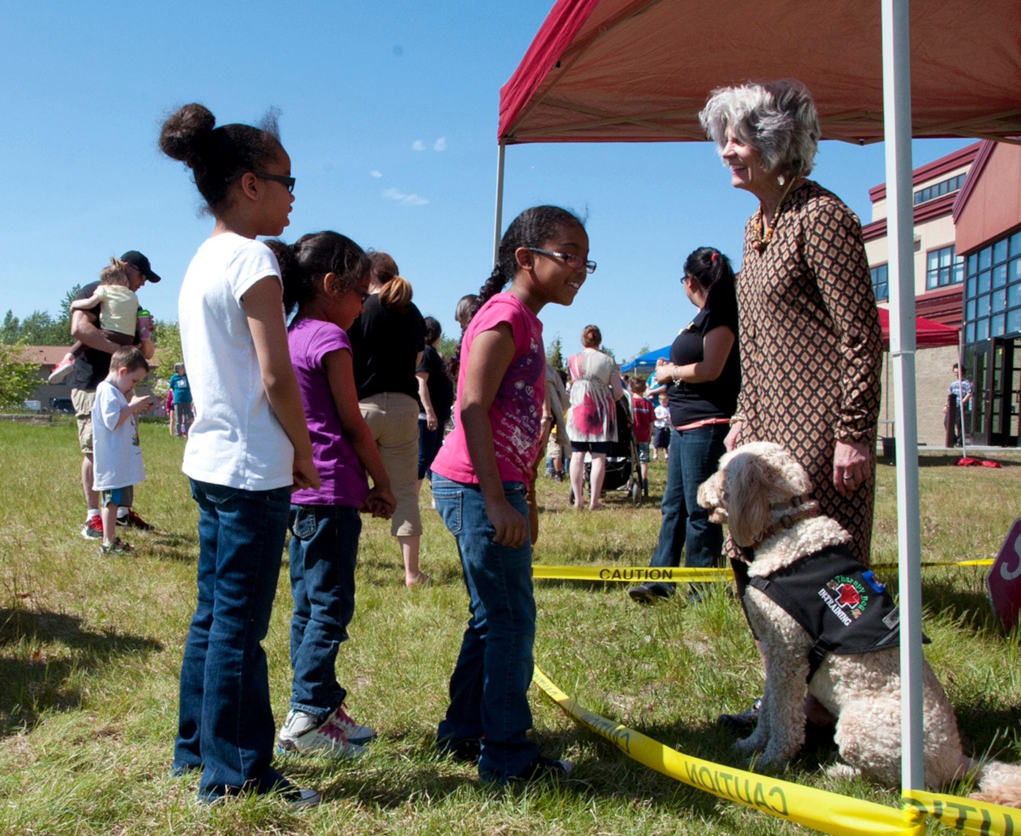 Children wait in line to pet a service dog during one of the ‘Paws to Read’ events at the Consolidated Library on Joint Base Elmendorf-Richardson, Alaska, June 5, 2014. Children were allowed to touch the service dog only after using a hand gesture the dog would understand to not be a threat. This is the fifth year the library has hosted the Summer Reading Program on JBER. (U.S. Air Force photo/Airman 1st Class Tammie Ramsouer)