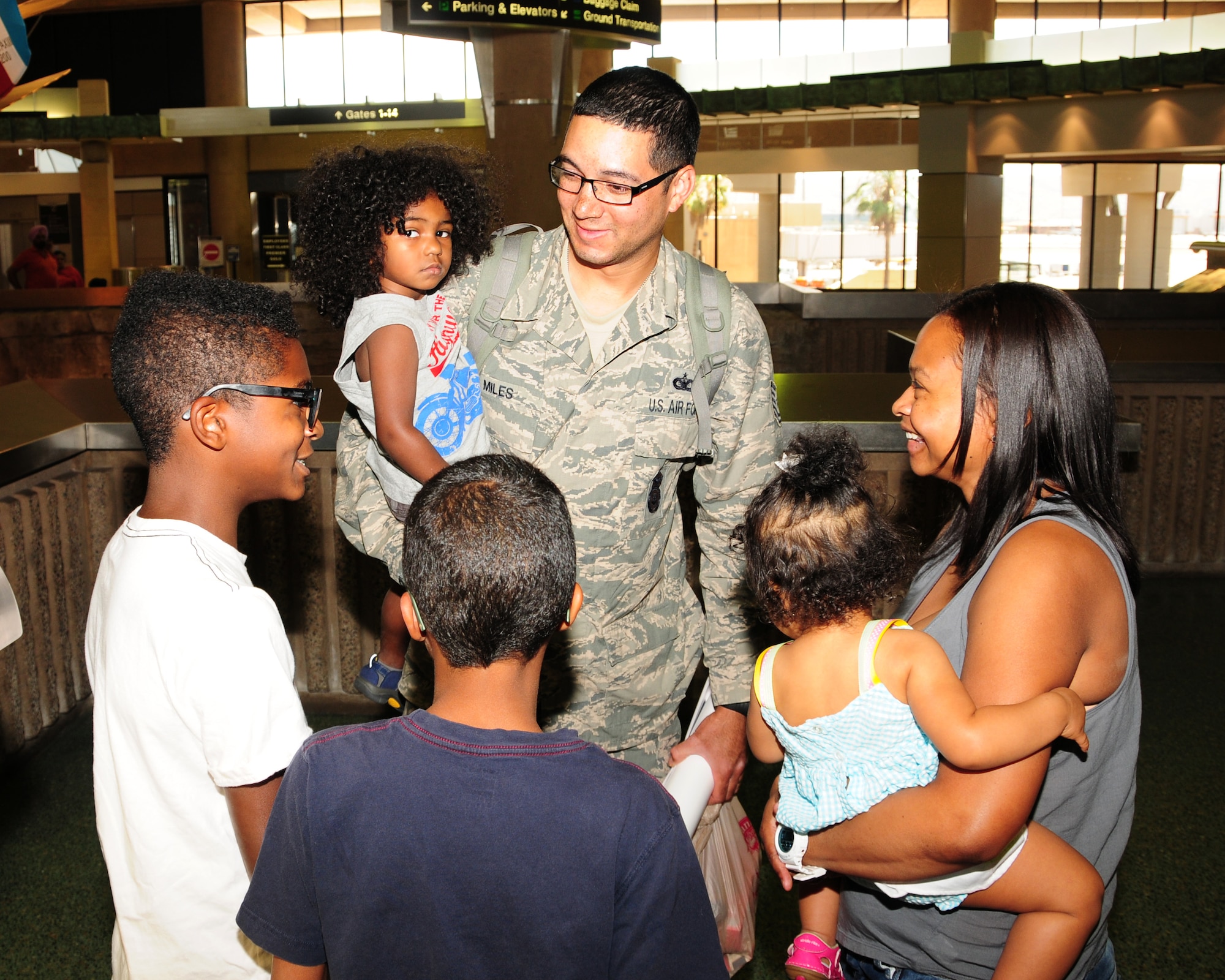 Tech. Sgt. Nicholas Miles, 944th Security Forces Squadron, reunites with his family June 16 after his return from a five month deployment overseas in support of the Transit Center at Manas. (U.S. Air Force photo taken by Tech. Sgt. Louis Vega Jr.)