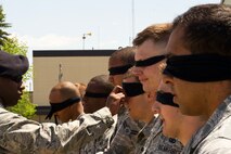 Members of the 791st Missile Security Forces Squadron are blindfolded during the Top Dog competition at Minot Air Force Base, N.D., June 12, 2014. The flight with the best overall time wins bragging rights until the next Top Dog competition. (U.S. Air Force photo/Senior Airman Brittany Y. Bateman)