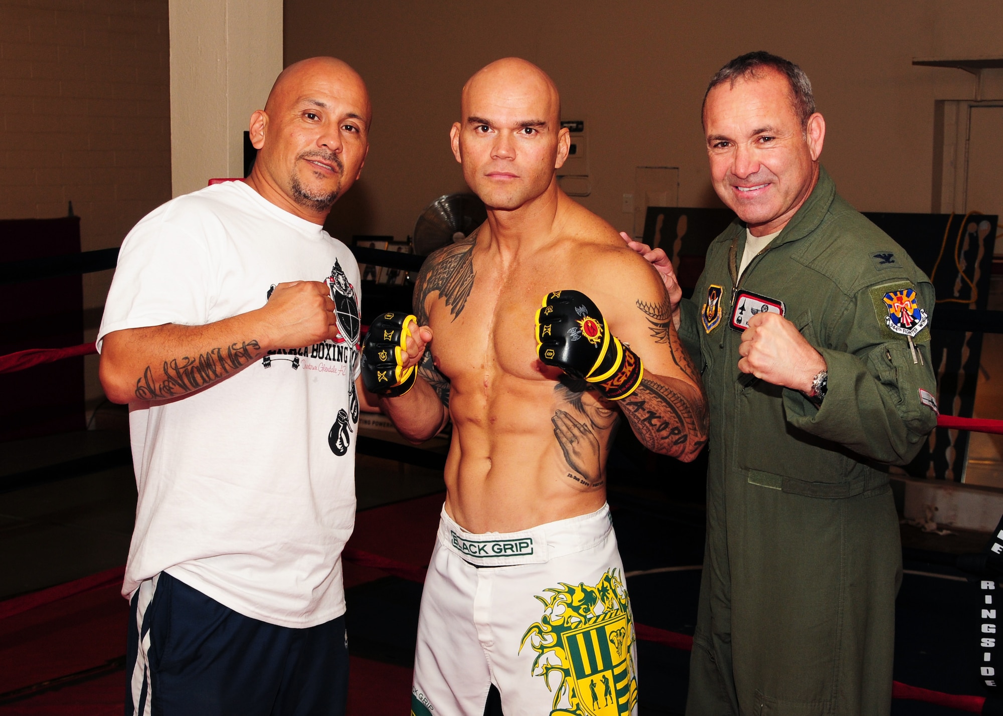 From left to right Cesar Peraza, Owner of Peraza Boxing and Mixed Martial Arts Gym and trainer, Master Sgt. Stanley Iakopo, 944th Fighter Wing Reserve recruiter, and Col. Kurt J. Gallegos, 944th FW commander, pose for a photo June 12 during Master Sgt. Iakopo’s final workout session prior to his fight in the Duel for Domination MMA event. (U.S. Air Force photo taken by Tech. Sgt. Louis Vega Jr.) 