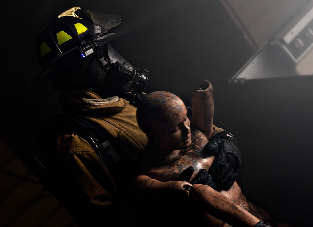 U.S. Army Spc. Adam North, South Dakota Army National Guard 451st Engineering Detachment Firefighting Team specialist, evacuates a casualty from a simulated burning structure as part of the 2014 Golden Coyote exercise at Ellsworth Air Force Base, S.D., June 11, 2014. Units from 17 states and three foreign countries participated in the exercise, allowing them to focus on training designed to prepare for real-world contingencies. (U.S. Air Force photo by Senior Airman Zachary Hada/Released)
