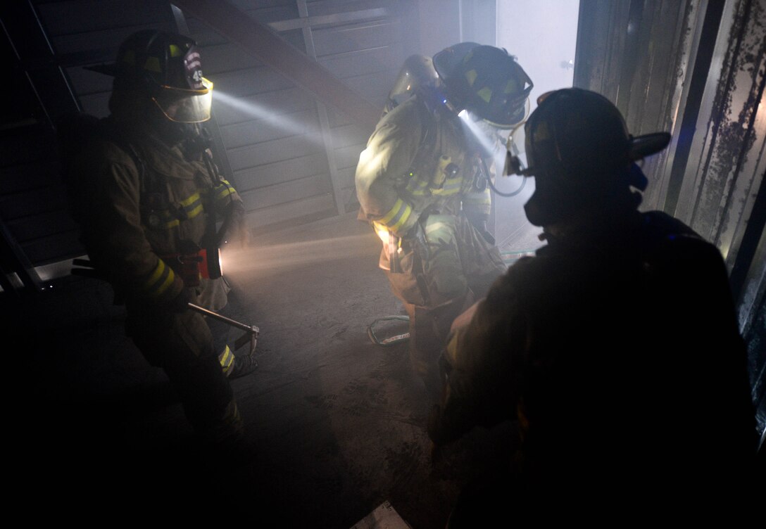 Firefighters assigned to the South Dakota Army National Guard 451st Engineering Detachment Firefighting Team, look for casualties during simulated search and rescue training as part of the 2014 Golden Coyote exercise at Ellsworth Air Force Base, S.D., June 11, 2014. The joint training exercise consists of three-phases and is conducted annually each June. (U.S. Air Force photo by Senior Airman Zachary Hada/Released)