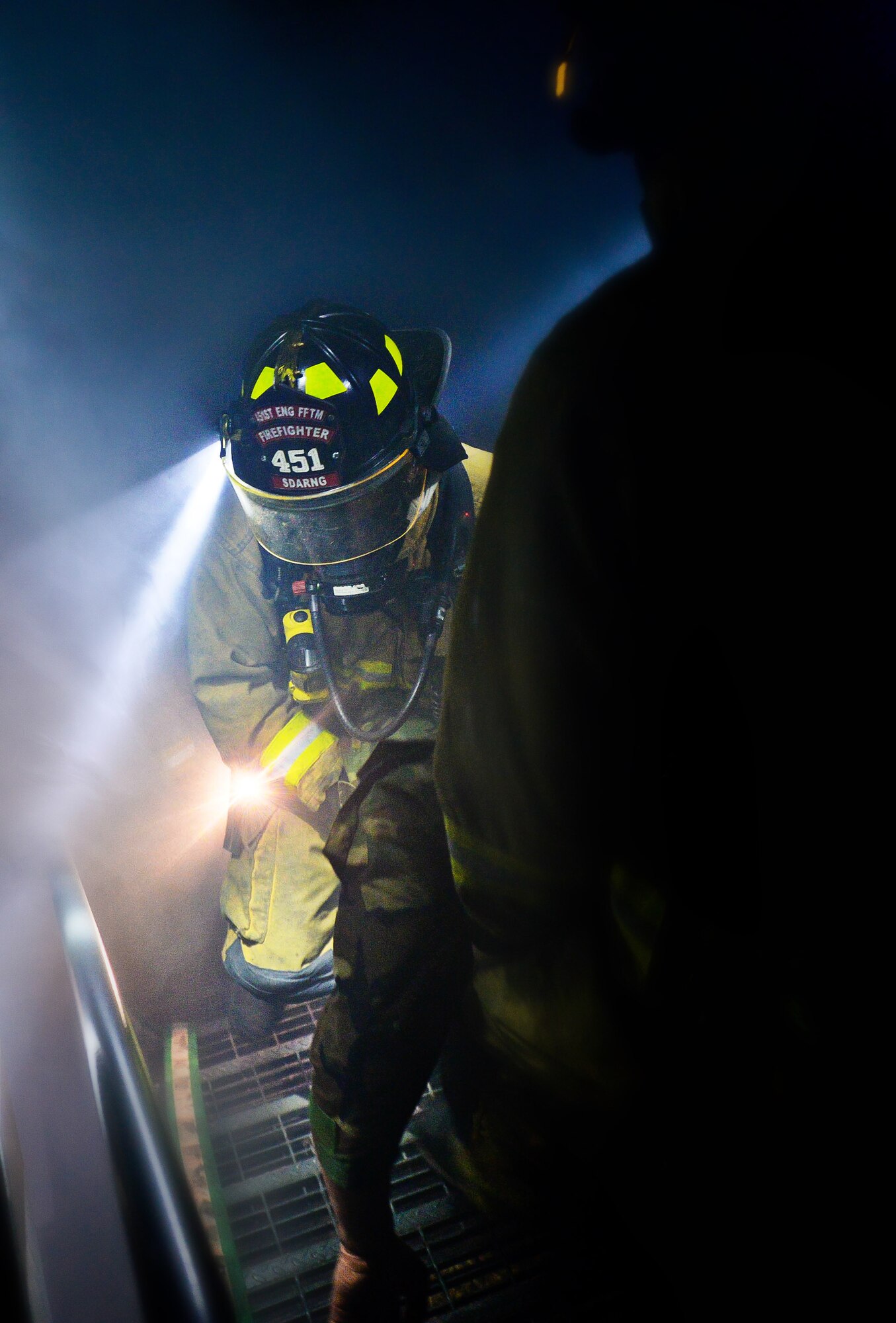 U.S. Army Spc. Adam North, South Dakota Army National Guard 451st Engineering Detachment Firefighting Team specialist, practices evacuation techniques in a simulated burning structure as part of the 2014 Golden Coyote exercise at Ellsworth Air Force Base, S.D., June 11, 2014. The exercise allows firefighters to safely improve search and rescue capabilities and fire response skills. (U.S. Air Force photo by Senior Airman Zachary Hada/Released)
