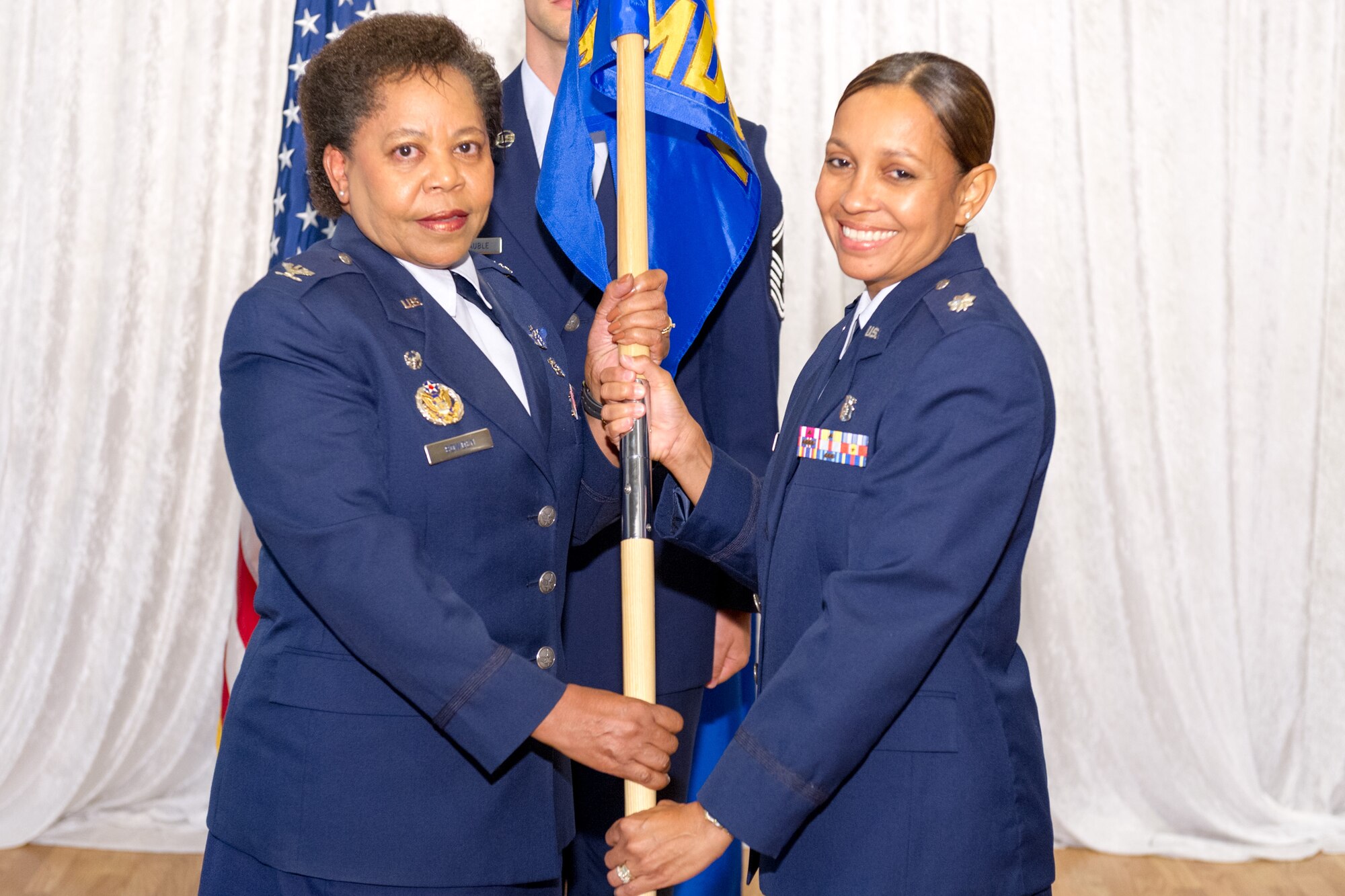 Col. Allison Bowden, 45th Medical Group commander, presents Lt. Col. Cherie-Anne Mauntel, 45th Medical Operations Squadron commander, with the 45th MDOS guide-on during a change of command ceremony June 12, 2014, at Patrick Air Force Base, Fla. Changes of command are a military tradition representing the transfer of responsibilities from the presiding officials to the upcoming official. (U.S. Air Force photo/Cory Long)