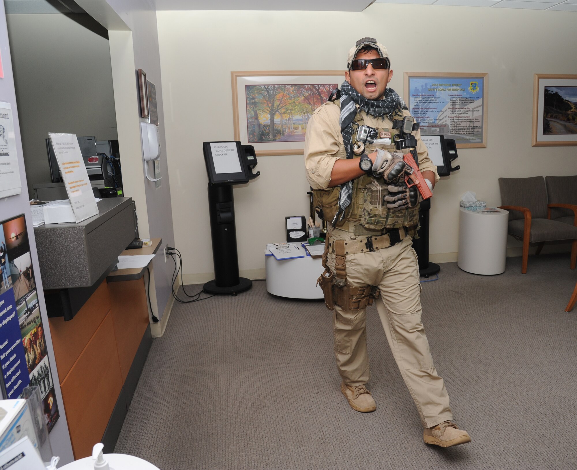 Staff Sgt. Joey Cedillo, 335th Training Squadron, portrays a gunman searching for victims during Keesler's active shooter exercise, June 11, 2014, at the Keesler Medical Center, Keesler Air Force Base, Miss.  Cedillo portrays an Air Force student simulated opening fire at the hospital after feeling he was wrongfully diagnosed.  The exercise tested the base's ability to respond to and recover from a mass casualty event.  (U.S. Air Force photo by Kemberly Groue)