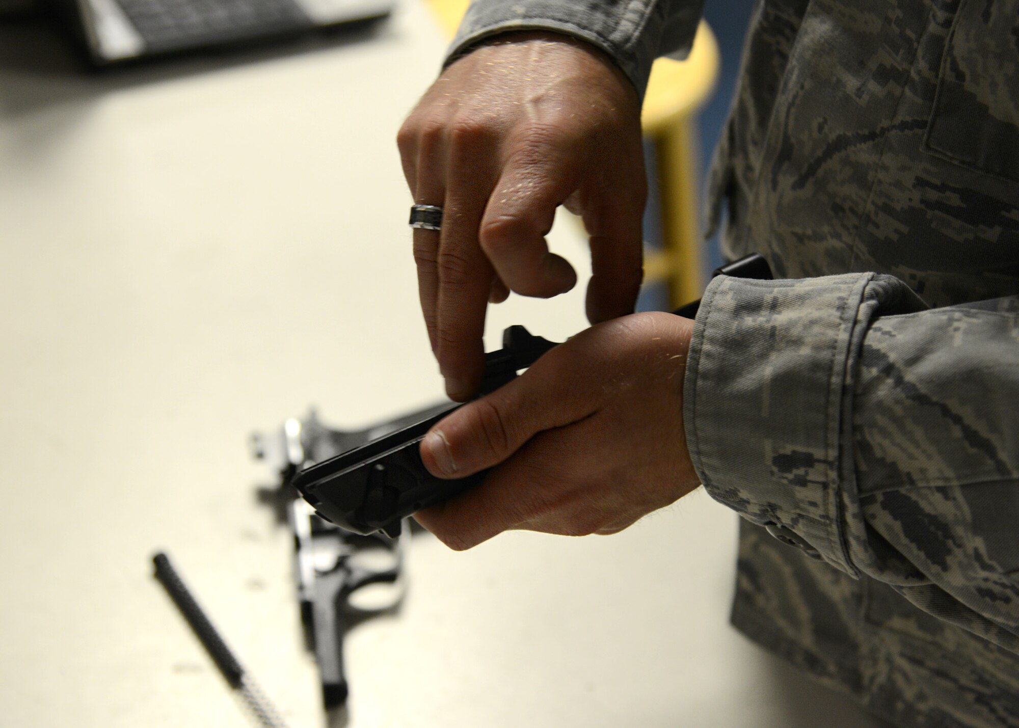 U.S. Air Force Senior Airman Mark Walker, 633rd Security Forces Squadron armorer, field strips an M9 handgun at the squadron armory at Langley Air Force Base, Va., June 11, 2014. The armorers ensure each weapon is serviceable, performing routine cleaning and minor maintenance on the more than 1,000 firearms in the inventory. (U.S. Air Force photo by Senior Airman Jason J. Brown/Released)