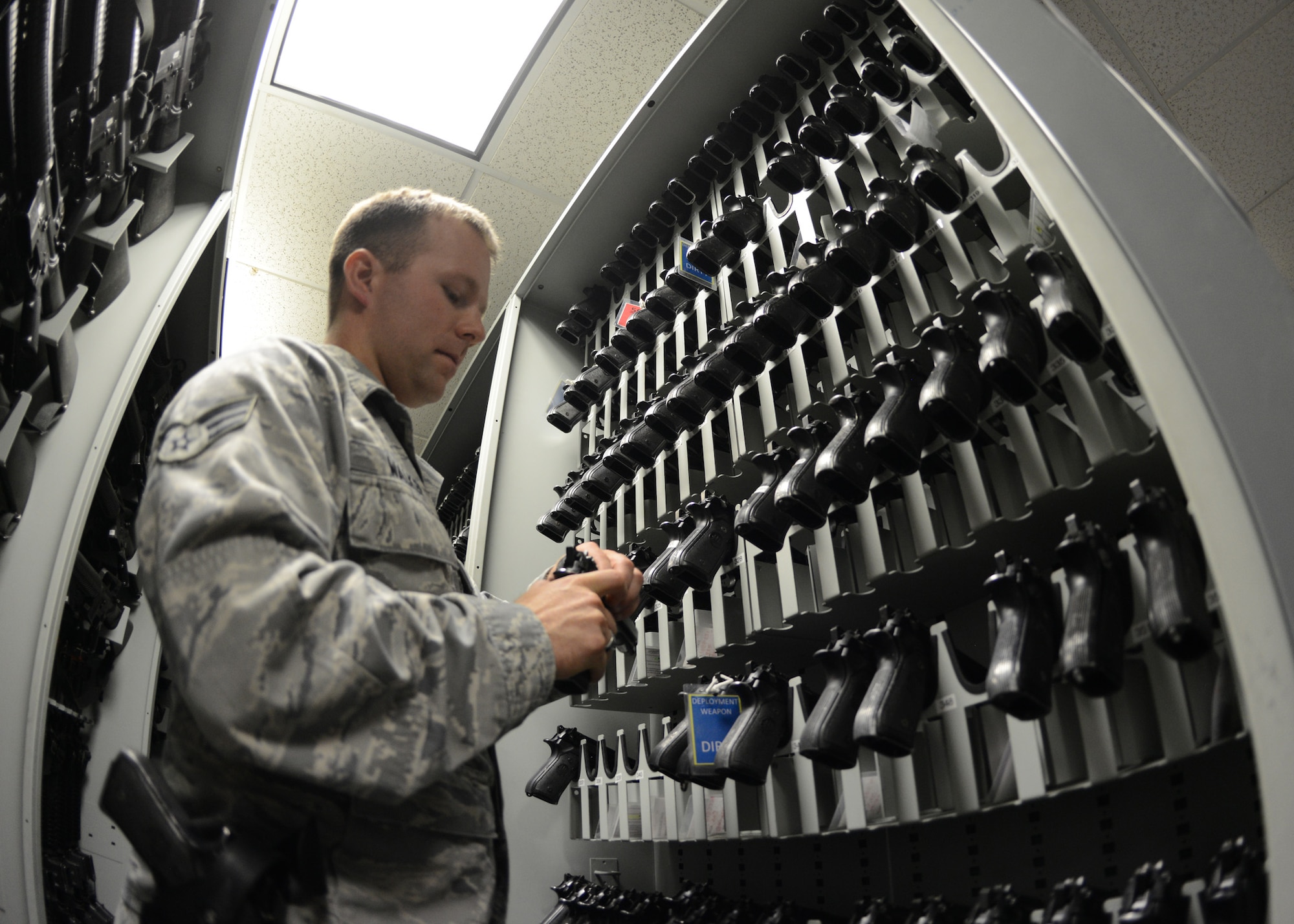 U.S. Air Force Senior Airman Mark Walker, 633rd Security Forces Squadron armorer, inspects an M9 handgun at the squadron armory at Langley Air Force Base, Va., June 11, 2014. The armory stores and maintains accountability for nearly every weapon on the installation, including firearms and ammunition issued to all Airmen deploying downrange. (U.S. Air Force photo by Senior Airman Jason J. Brown/Released)