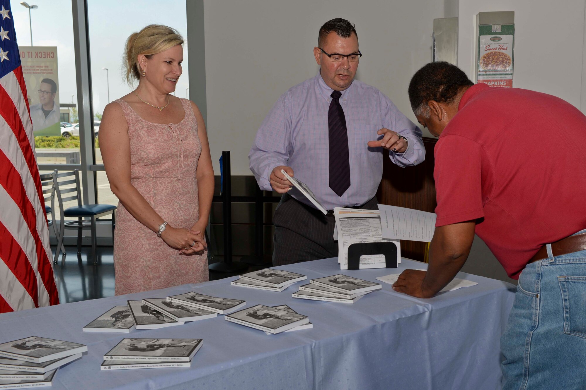 Lisa Henry, left, and Charles Navarro, center, both from the Spangdahlem Veterans Benefits Affairs Department of Defense program, assist Thomas Williams, 52nd Force Support Squadron Teen Center director, during a display at the Base Exchange food court at Spangdahlem Air Base, Germany, June 11, 2014. The program aims to assist transitioning Airmen and their families as part of President Barack Obama’s Veterans Opportunity to Work Act, which makes service member participation in the Transition Assistance Program mandatory. (U.S. Air Force photo by Staff Sgt. Joe W. McFadden/Released)