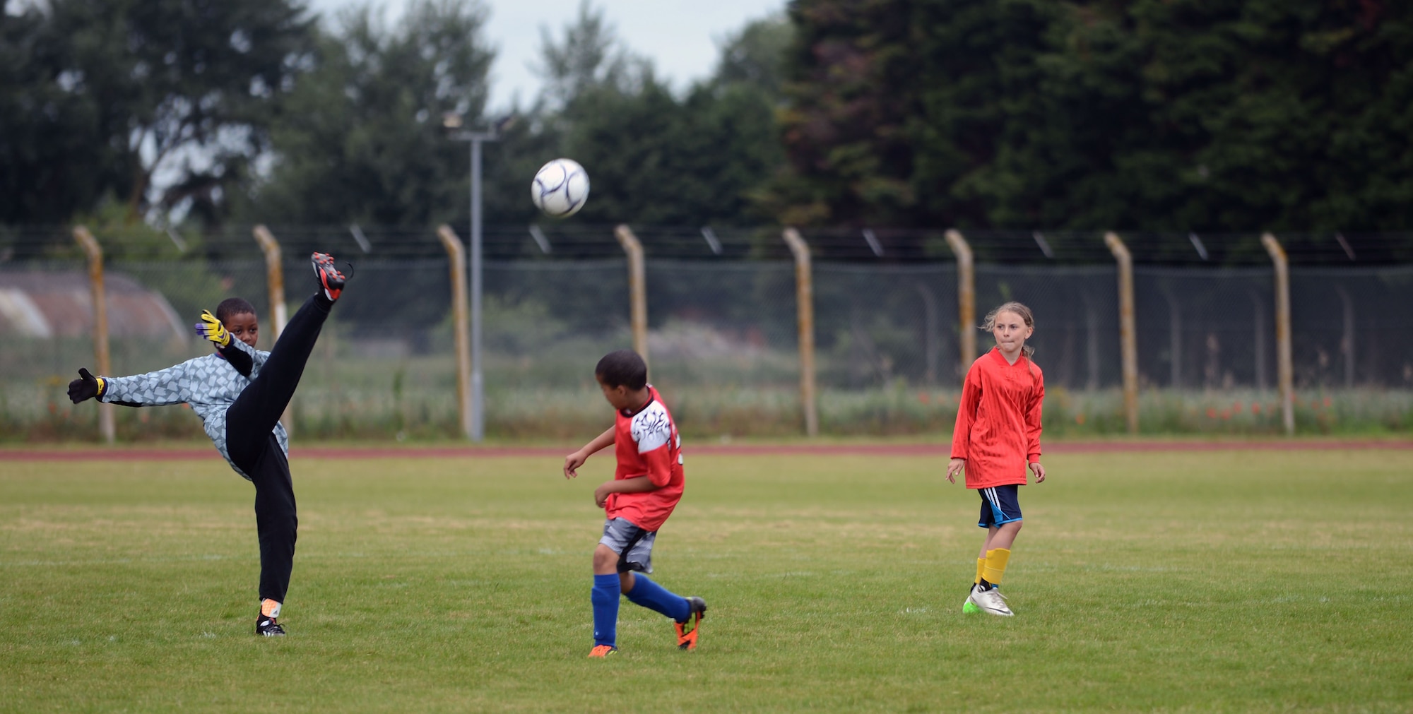 The goalie for the Black Knights, RAF Lakenheath Liberty Wing’s youth all-star soccer team, punts a soccer ball June 14, 2014, at Heritage Park on RAF Mildenhall, England. The Black Knights defeated the Team Mildenhall youth all-star soccer team, the Red Dragons, in two games 2-0 and 3-0 respectively. (U.S. Air Force photo/Airman 1st Class Preston Webb/Released)