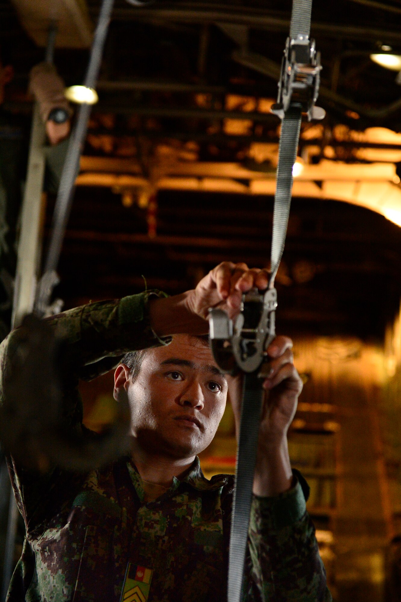 Afghan Nation Army soldier prepares clamps to hold litter patience on a C-130H1 Hercules during an Afghan Air Force casualty evacuation mission, Kabul, Afghanistan, May 19, 2014. The medical crew traveled along with the AAF to provide help transporting 60 ANA soldiers. (U.S. Air Force photo by Staff Sgt. Vernon Young Jr.)