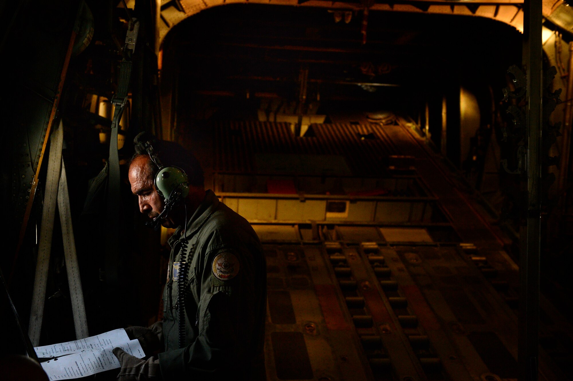 Sgt. Shanawaz Nabi Zada, Afghan Air Force loadmaster, opens his pre-flight checklist to review prior to takeoff in Kabul, Afghanistan, May 19, 2014. As a loadmaster Nabi Zada is responsible for briefing Afghan passengers on safety, enforcing flying standards and evenly distributing weight throughout the aircraft.  Nabi Zada has been trained on his load master duties and responsibilities by advisors assigned to the 438th Air Expeditionary Advisory Squadron. (U.S. Air Force photo by Staff Sgt. Vernon Young Jr.)