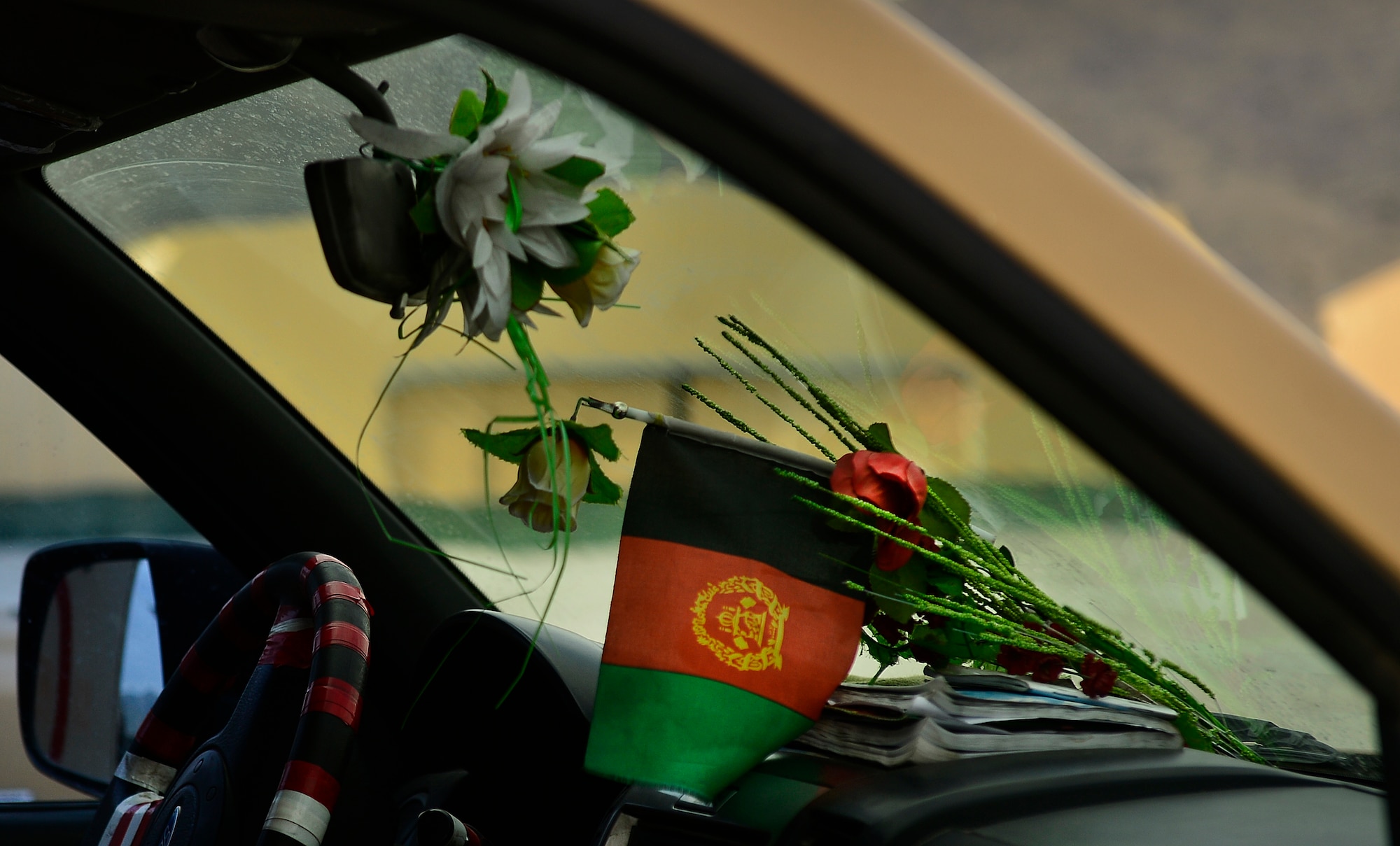 Flowers remain in the dashboard of an Afghan National Army vehicle during a human remains transfer, Kabul, Afghanistan, May 19, 2014. The Afghan aircrew successfully loaded the human remains, ANA soldiers and other personnel during a casualty evacuation mission. (U.S. Air Force photo by Staff Sgt. Vernon Young Jr.)