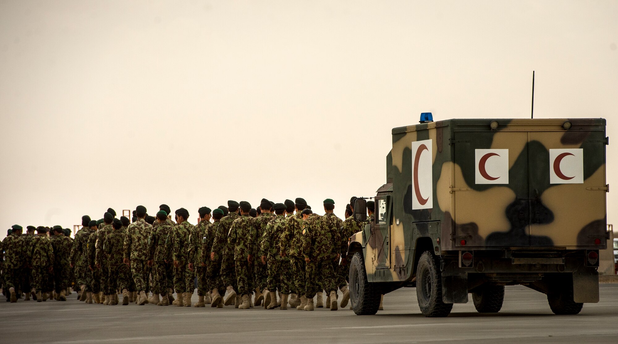 Afghan National Army soldiers walk alongside a ANA medical vehicle after human remains of ANA soldiers are loaded onto a C-130H1 Hercules during a casualty evacuation mission, Camp Bastion, Afghanistan, May 19, 2014. The Afghan aircrew successfully loaded the human remains, ANA soldiers and other personnel. The aircrew assisted 16 injured patients onto stretchers and into comfortable position during the CASEVAC mission.  (U.S. Air Force photo by Staff Sgt. Vernon Young Jr.)