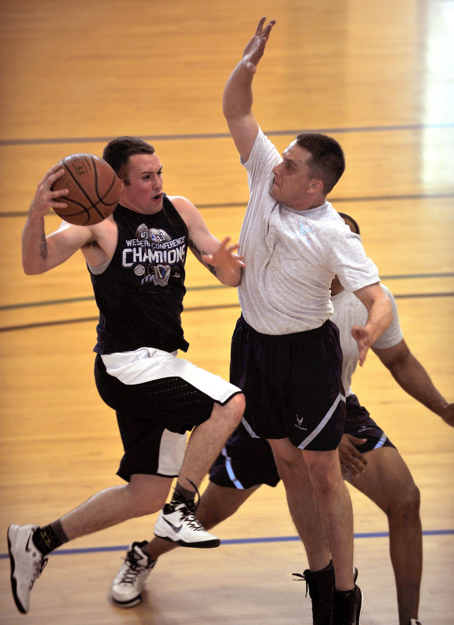 U.S. Air Force Senior Airman Joseph Rowan, left, 100th Maintenance Squadron from Oceanside, Cali., tries to shoot a basketball during the Marauder Melee 3-on-3 basketball tournament June 13, 2014, at the Hardstand Fitness Center on RAF Mildenhall, England. The event started with a 5 km run followed by dodgeball, volleyball, a fitness challenge and an obstacle race. (U.S. Air Force photo/Senior Airman Christine Griffiths/Released)