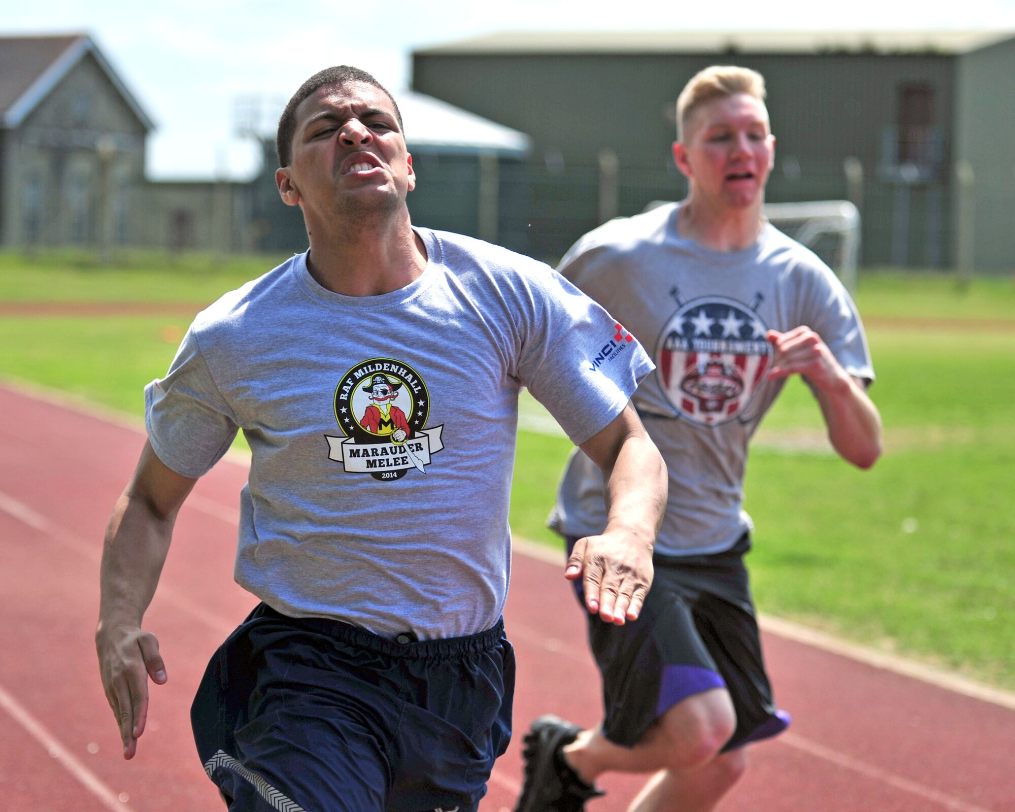 U.S. Air Force Airman 1st Class Glenn Gonzalez, left, 100th Force Support Squadron career development office separations clerk from Ellington, Conn., and Airman 1st Class Steven Schulze, 100th Logistics Readiness Squadron traffic management office from Oshkosh, Wis., compete in the 100-meter dash during the Marauder Melee June 13, 2014, at the Heritage Park Track on RAF Mildenhall, England. The event started with a 5 km run followed by dodgeball, volleyball, a fitness challenge and an obstacle race. (U.S. Air Force photo/Senior Airman Christine Griffiths/Released) 