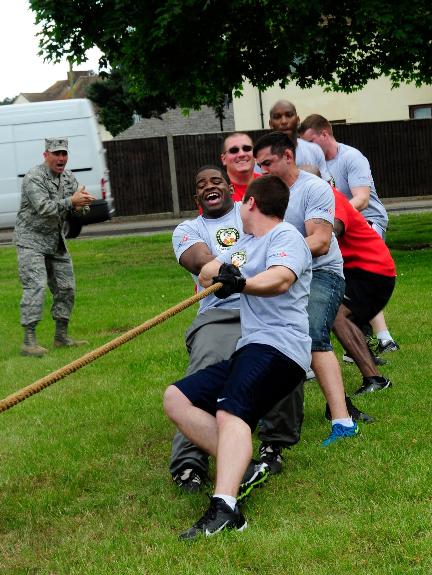 Members from the 100th Communications Squadron work together to bring down the 100th Maintenance Group, as U.S. Air Force Lt. Col. Albert Franke, 100th CS commander, cheers them on at the Marauder Melee June 13, 2014, on RAF Mildenhall, England. The 100th CS team beat 100th MXG. The event was open to families in the afternoon and included activities such as water zorbing, bouncy castles, a mechanical bull and a petting zoo. (U.S. Air Force photo/Karen Abeyasekere/Released)