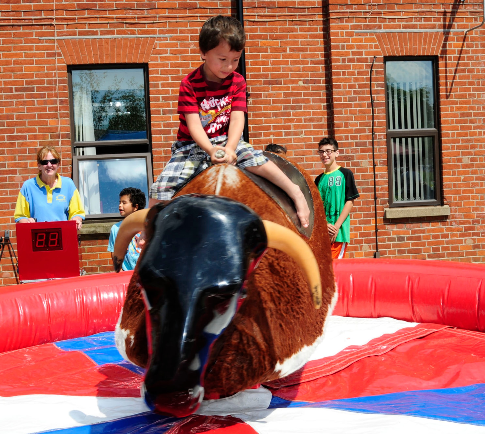 Matthew Joiner, 5, son of U.S. Air Force Tech. Sgt. Neal Joiner, 100th Air Refueling Wing Public Affairs NCO in charge of plans and programs from Bollinger County, Mo., takes a turn on the mechanical bull June 13, 2014, at the Marauder Melee on RAF Mildenhall, England. Team Mildenhall members participated in sporting events including a 5 km run, dodgeball, volleyball and tug-of-war. The event was open to families in the afternoon and included activities such as water zorbing, bouncy castles, a bungee run and a petting zoo. (U.S. Air Force photo/Karen Abeyasekere/Released)