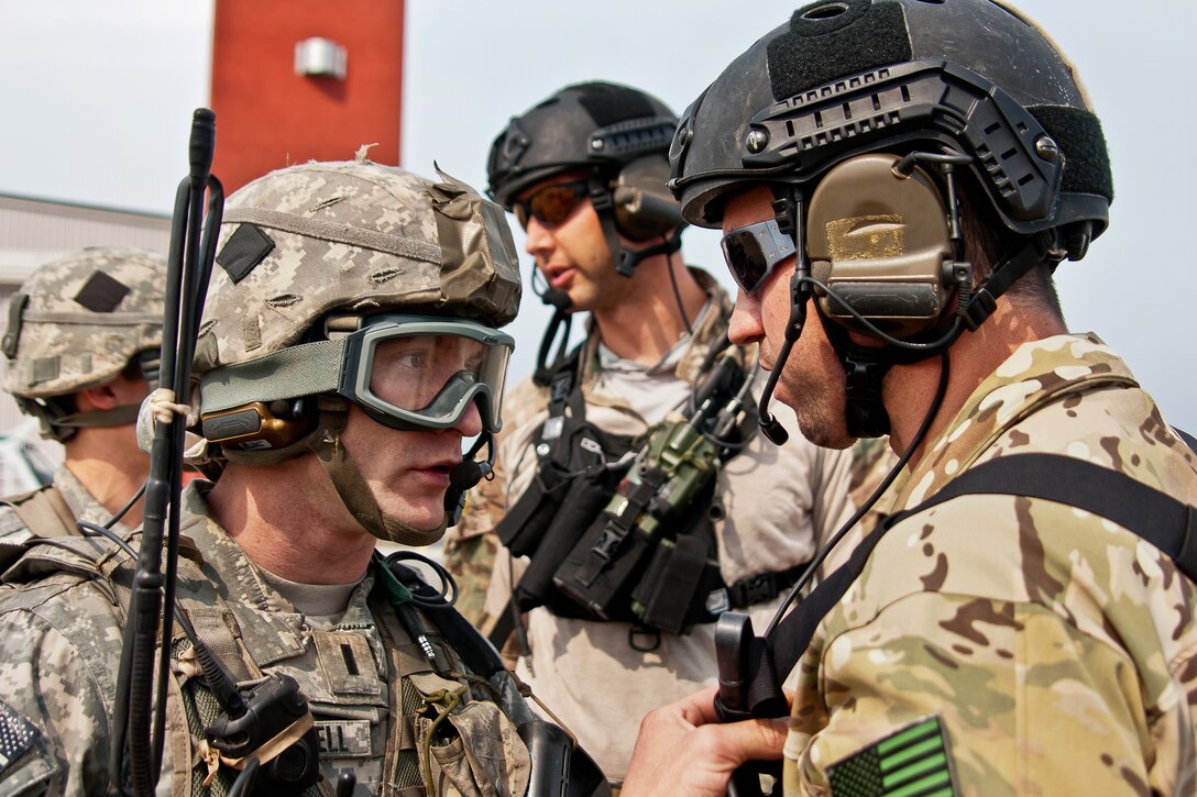 A soldier, left, coordinates an air lift with an Air Force tactical controller at Allen Army Airfield on Fort Greely, Alaska, June 8, 2014. The soldier, a paratrooper, is assigned to the 25th Infantry Division's 4th Infantry Brigade Combat Team, Airborne. The training was part of a three-day, joint forcible-entry exercise to train airfield seizure operations.
