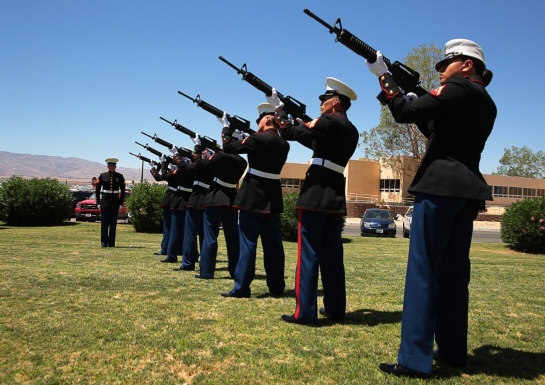Cpl. Tyler Hanson, motor transport mechanic, Exercise Support Division, leads a rifle team through a 21-gun salute during the memorial service for retired Marine Col. M.J. 'Mac' Dube at the base Catholic chapel, June 13, 2014.