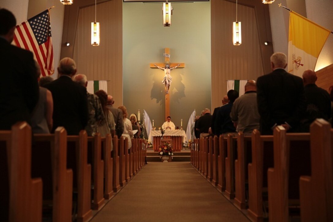 The congregation stands for a prayer during a memorial service for retired Marine Col. M.J. 'Mac' Dube at the base Catholic chapel, June 13, 2014. Dube served as mayor of Twentynine Palms for two terms before leaving the city council in 2002 and becoming the field representative to the First District Supervisor.