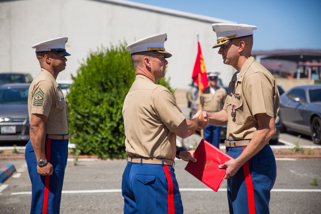 U.S. Marine Corps Col. Eric C. Hastings, middle, commanding officer, 12th Marine Corps District, shakes hands with Maj. Jason R. Fenton, right, outgoing commanding officer, Prior Service Recruiting, 12th Marine Corps District, after awarding him the Meritorious Service Medal aboard Camp Pendleton, Calif., June 17, 2014. Fenton had relinquished his command to Maj. Brad Burnett prior to being awarded. (U.S. Marine Corps photo by Cpl. Catie Massey, 12th Marine Corps District/Released)
