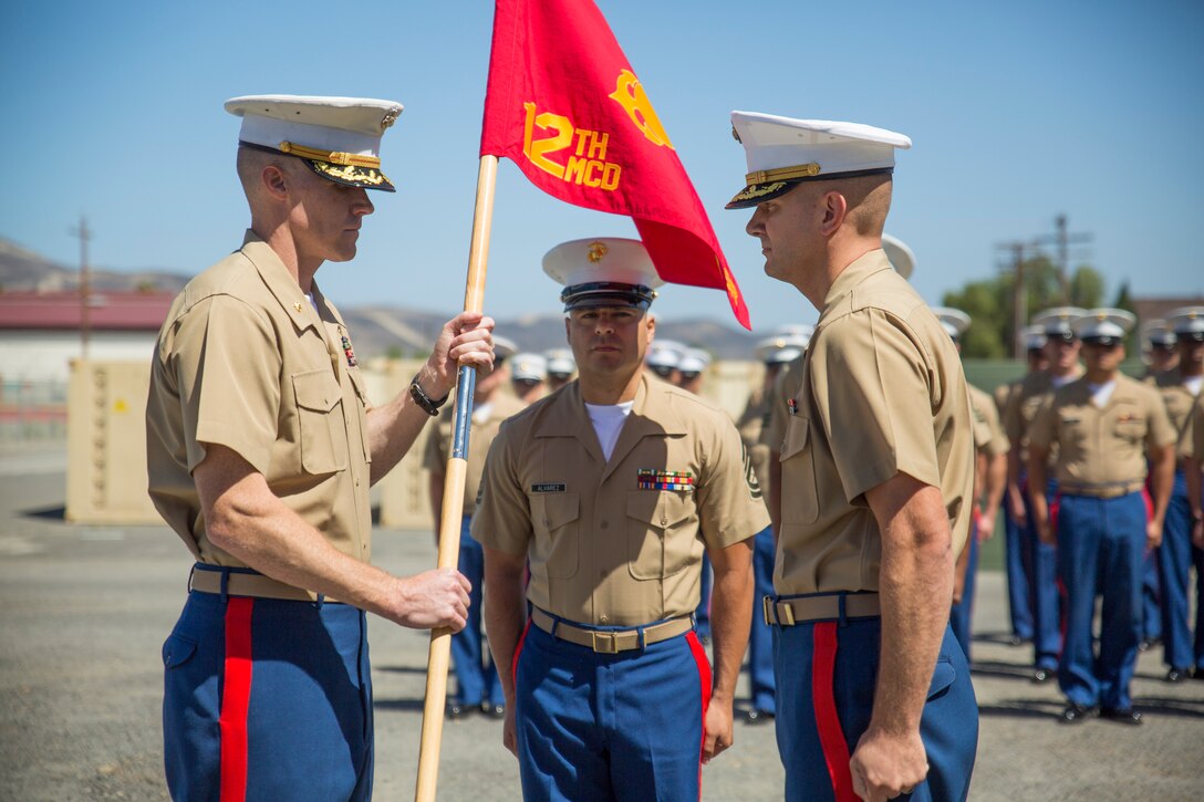 U.S. Marine Corps Maj. Jason R. Fenton, commanding officer, Prior Service Recruiting (PSR), passes off a guidon to Maj. Brad Burnett, oncoming commanding officer, PSR, aboard Camp Pendleton, Calif., June 17, 2014. The passing of the guidon symbolizes the transfer of authority from one Marine to another. (U.S. Marine Corps photo by Cpl. Catie Massey, 12th Marine Corps District/Released) 