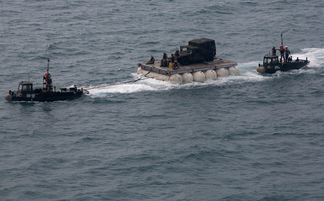 U.S. Marines and sailors pull a Lightweight Modular Causeway System with bridge erection boats during amphibious operations training in Mersing, Malaysia, June 13 as part of Exercise T-AKE 14-1. The service members are with Combat Logistics Detachment 302, which is a task organized company tailored to conduct operationalization of maritime prepositioning force assets and theater security cooperation during the exercise. The exercise focuses on MPF ship-to-shore connector proof of concept, military-to-military training, and humanitarian and disaster relief contingency planning, while expanding theater security cooperation with host nations. The service members are assigned to CLD-302, CLR-3, 3rd Marine Logistics Group, III Marine Expeditionary Force. (U.S. Marine Corps photo by Lance Cpl. Eric C. Clayton/Released)