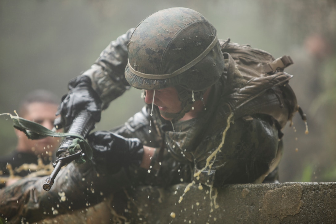 Cpl. Connor J. Adlington climbs over a wall after emerging from a river during the Jungle Endurance Course at Camp Gonsalves, June 14, 2014. Adlington is a machine gunner with Company K, Battalion Landing Team 3rd Battalion, 5th Marines, 31st Marine Expeditionary Unit, and a native of Menomonee Falls, Wisconsin. Multiple obstacles make up the endurance course, which tests physical and mental stamina, as well as unit cohesion. The 31st MEU is the force of choice for the Asia-Pacific region and is the only continuously forward-deployed MEU.