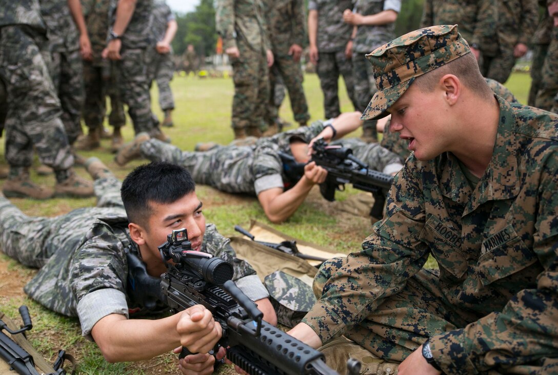 A Republic of Korea Marine, left, is instructed by Lance Cpl. Axel E. Hogberg June 7, 2014 at the 1st Republic of Korea Marine Division base in Pohang, South Korea. The Marines executed weapons familiarization training in preparation for Korean Marine Exchange Program 14-8, which is slated to take place June 9-21. KMEP is a regularly-scheduled, combined, small-unit training exercise, which enhances the combat readiness and interoperability of ROK-U.S. Marine Corps forces. Hogberg is a military policeman with Company A, 3rd Law Enforcement Battalion, III Marine Expeditionary Force Headquarters Group, III MEF.