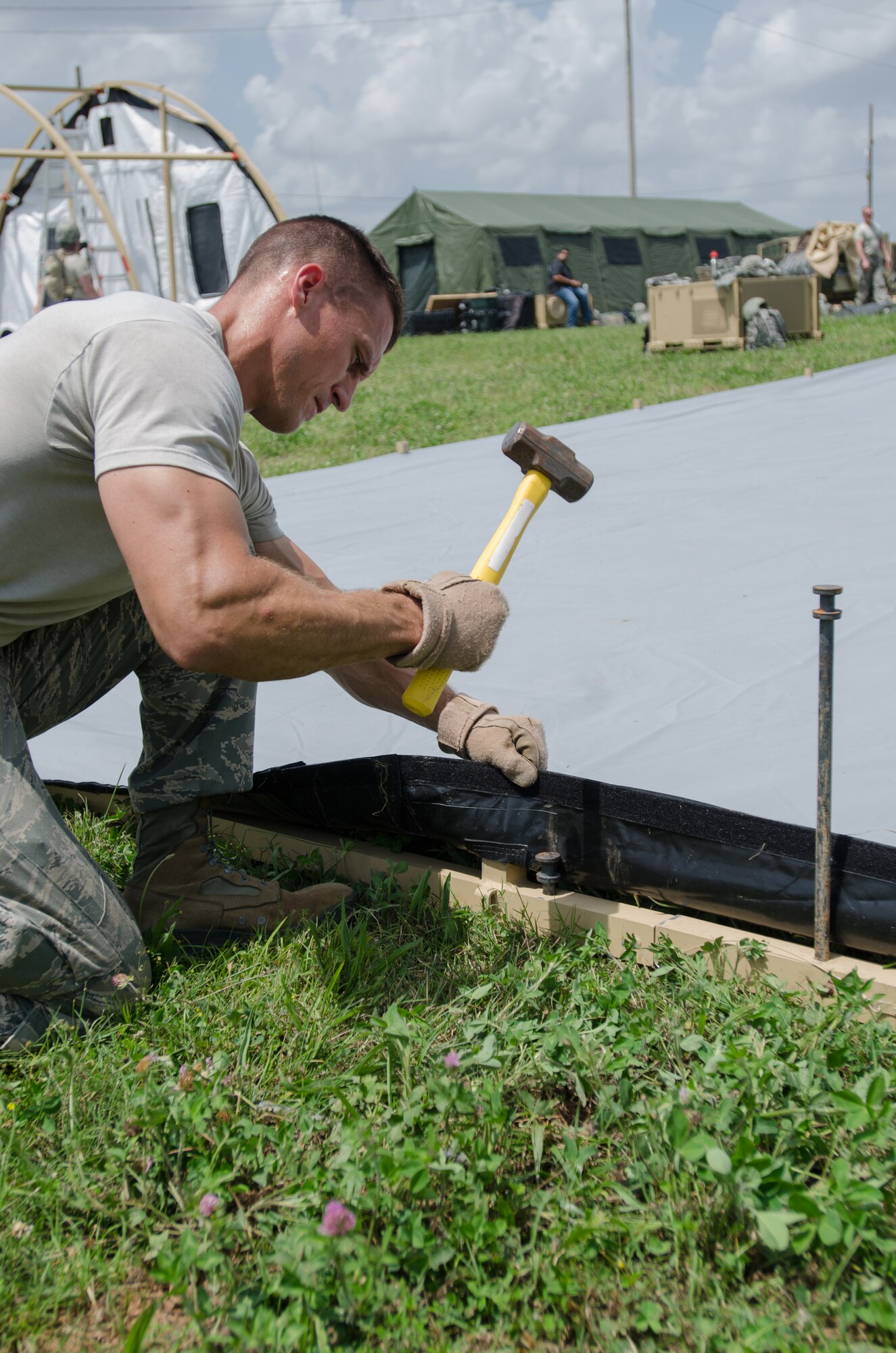 Tech. Sgt. Jason Prifogle, squad leader for the Kentucky Air National Guard’s 123rd Contingency Response Group, hammers stakes for an Alaskan Shelter during Capstone '14, a homeland earthquake-response exercise at Fort Campbell, Ky., on June 17, 2014. The 123rd CRG is joining with the U.S. Army’s 688th Rapid Port Opening Element to operate a Joint Task Force-Port Opening here from June 16 to 19, 2014. (U.S. Air National Guard photo by Master Sgt. Phil Speck)