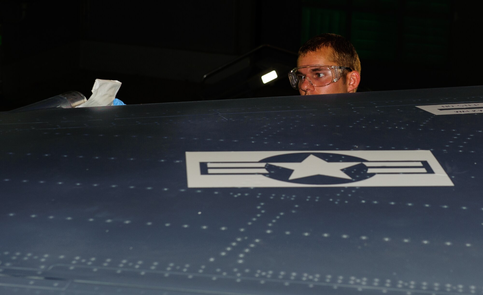 Senior Airman Chase Douget, 8th Maintenance Squadron Aircraft Structural Maintenance journeyman, cleans the leading edge of a jet prior to painting the Air Force Roundel on the wing during full-scale depot-level maintenance at Kunsan Air Base, Republic of Korea, June 11, 2014. Douget and the corrosion control section conducted a full wing-to-wing paint job in 10 work days, beating the expected 14 at a depot. U.S. Air Force photo by Senior Airman Armando A. Schwier-Morales/Released)