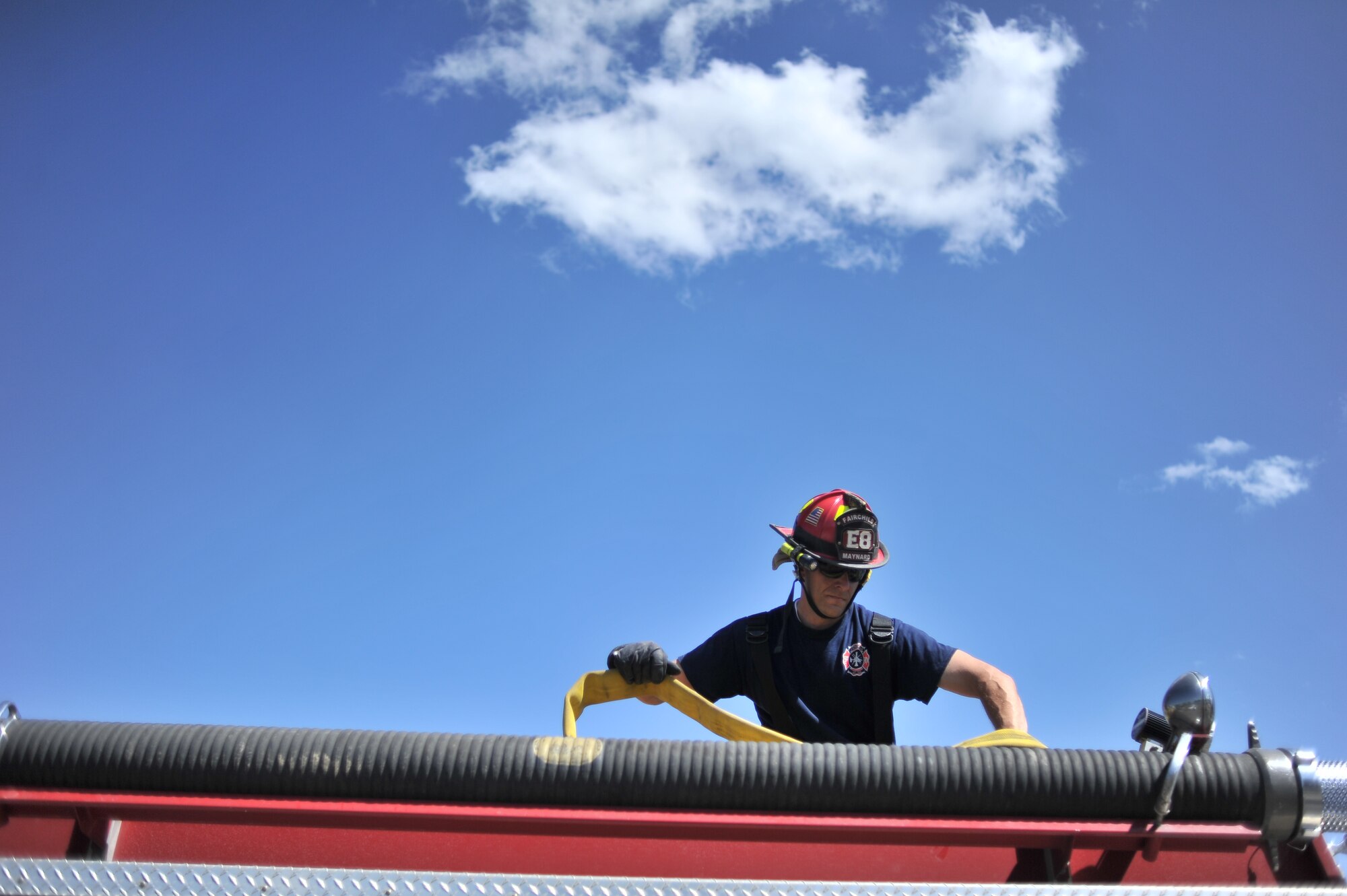 Kristofer Maynard, 92nd Civil Engineer Squadron firefighter, begins to recoil a fire hose back on to the fire-engine after Rapid Intervention Team training at Fairchild Air Force Base, Wash., June 13, 2014. Fairchild hosted 14 Airmen from seven separate Fire Stations throughout the Air Force Space Command. Teams of two train together in buildings compiled with scenarios that help mimic the real life possibilities of being trapped, injured or lost. (U.S. Air Force photo by Staff Sgt. Alexandre Montes/Released)