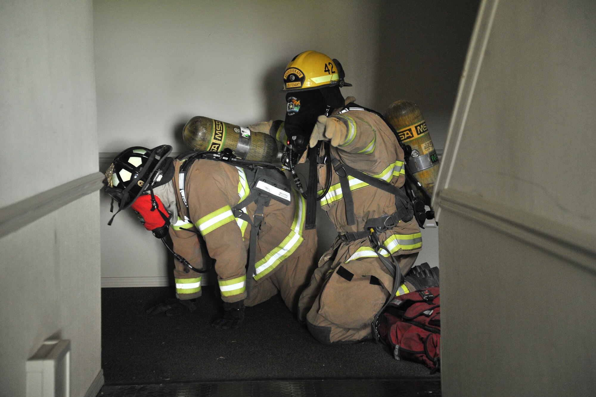 Trainees attempt to look for and exit to renew their oxygen tanks during Rapid Intervention Team training at Fairchild Air Force Base, Wash., June 13, 2014. Fairchild hosted 14 Airmen from seven separate Fire Stations throughout the Air Force Space Command. Teams of two train together in buildings compiled with scenarios that help mimic the real life possibilities of being trapped, injured or lost. (U.S. Air Force photo by Staff Sgt. Alexandre Montes/Released)
