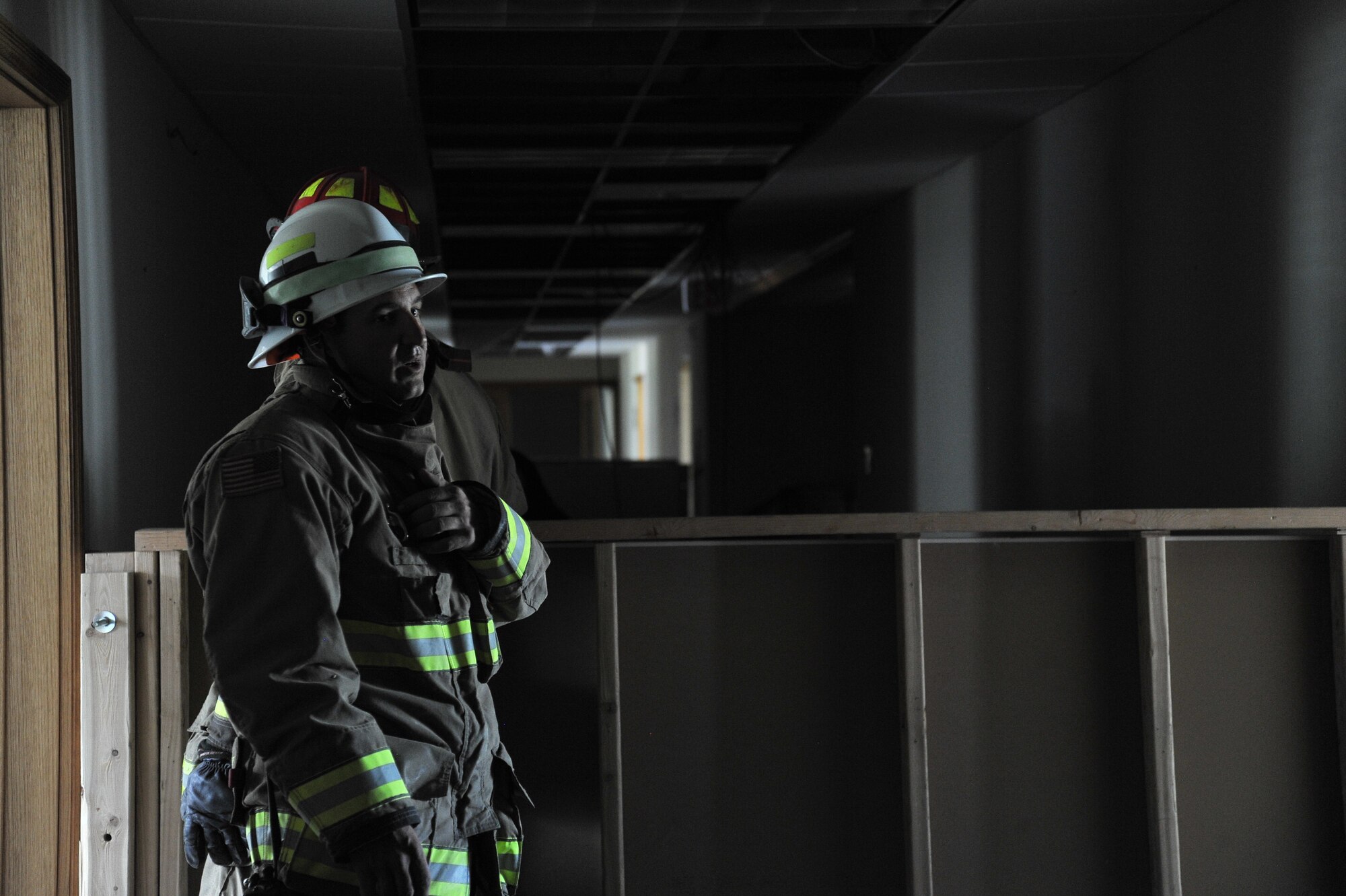 David Killpack, 92nd Civil Engineer Squadron training chief, calls in the first group of trainees to begin navigating through a simulated burning building during Rapid Intervention Team training at Fairchild Air Force Base, Wash., June 13, 2014. Fairchild hosted 14 Airmen from seven separate Fire Stations throughout the Air Force Space Command. Teams of two train together in buildings compiled with scenarios that help mimic the real life possibilities of being trapped, injured or lost. (U.S. Air Force photo by Staff Sgt. Alexandre Montes/Released)