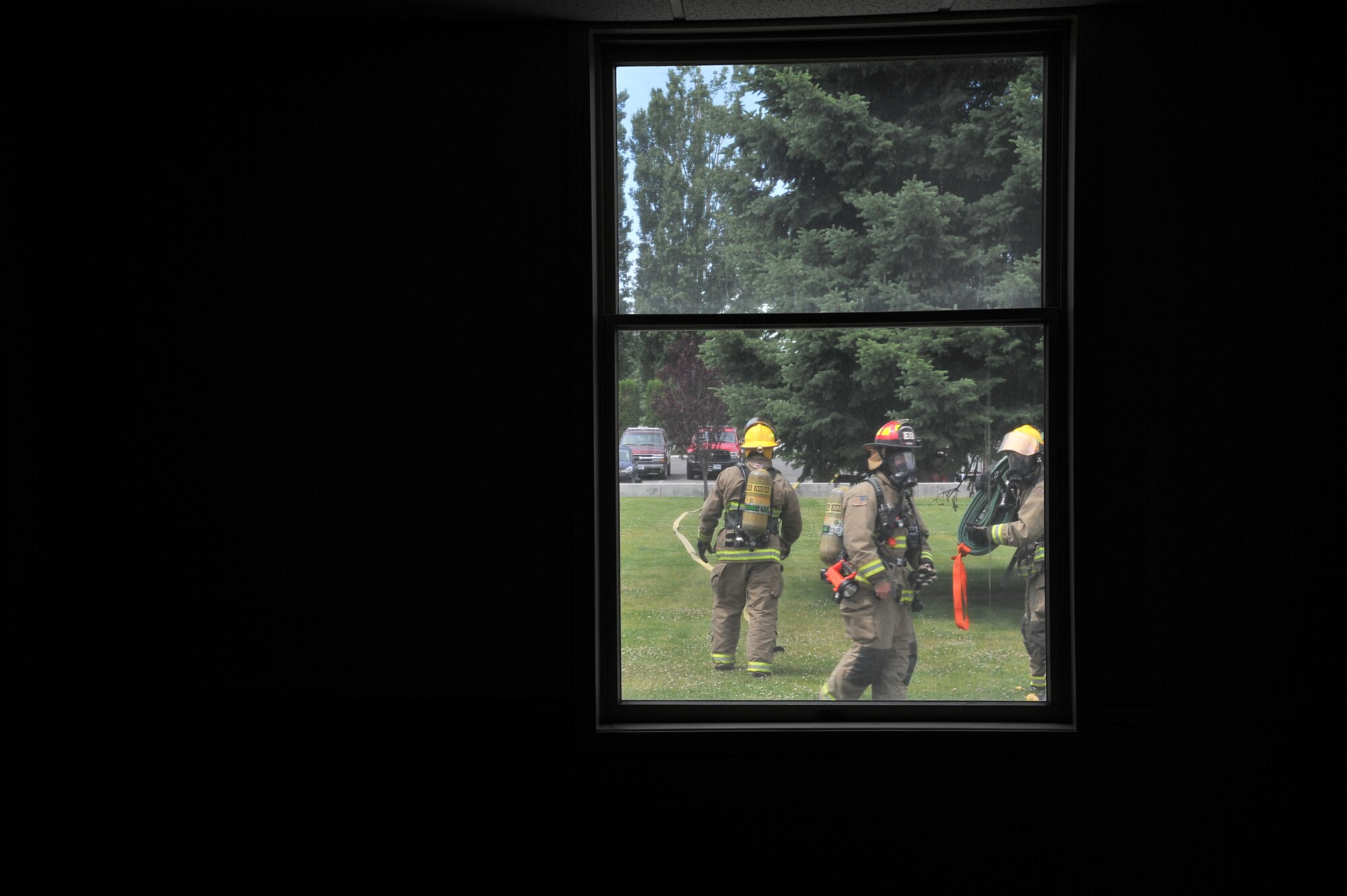 Airmen from the 92nd Civil Engineer Squadron & Air Force Space Command prepare their equipment prior to participating in Rapid Intervention Team training at Fairchild Air Force Base, Wash., June 13, 2014. Fairchild hosted 14 Airmen from seven separate Fire Stations throughout the Air Force Space Command. Teams of two train together in buildings compiled with scenarios that help mimic the real life possibilities of being trapped, injured or lost. (U.S. Air Force photo by Staff Sgt. Alexandre Montes/Released)